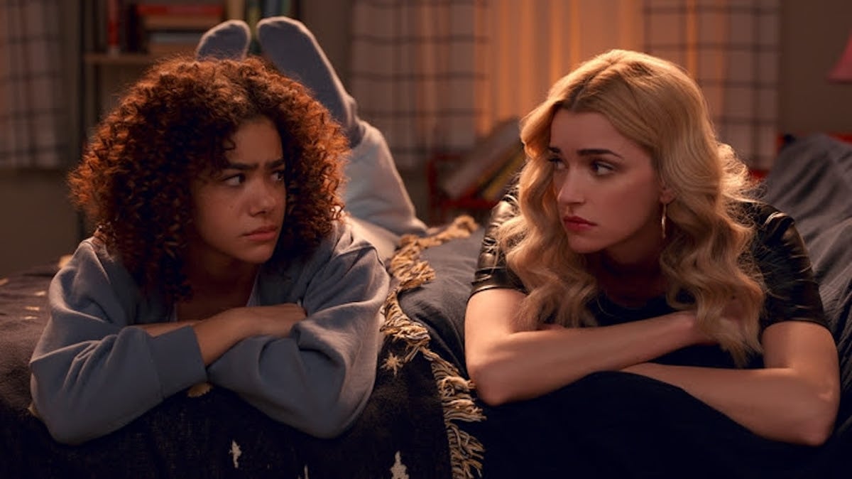 Antonia Gentra as Ginny and Brianne Howey and Georgia laying across a bed chatting in 'Ginny & Georgia'