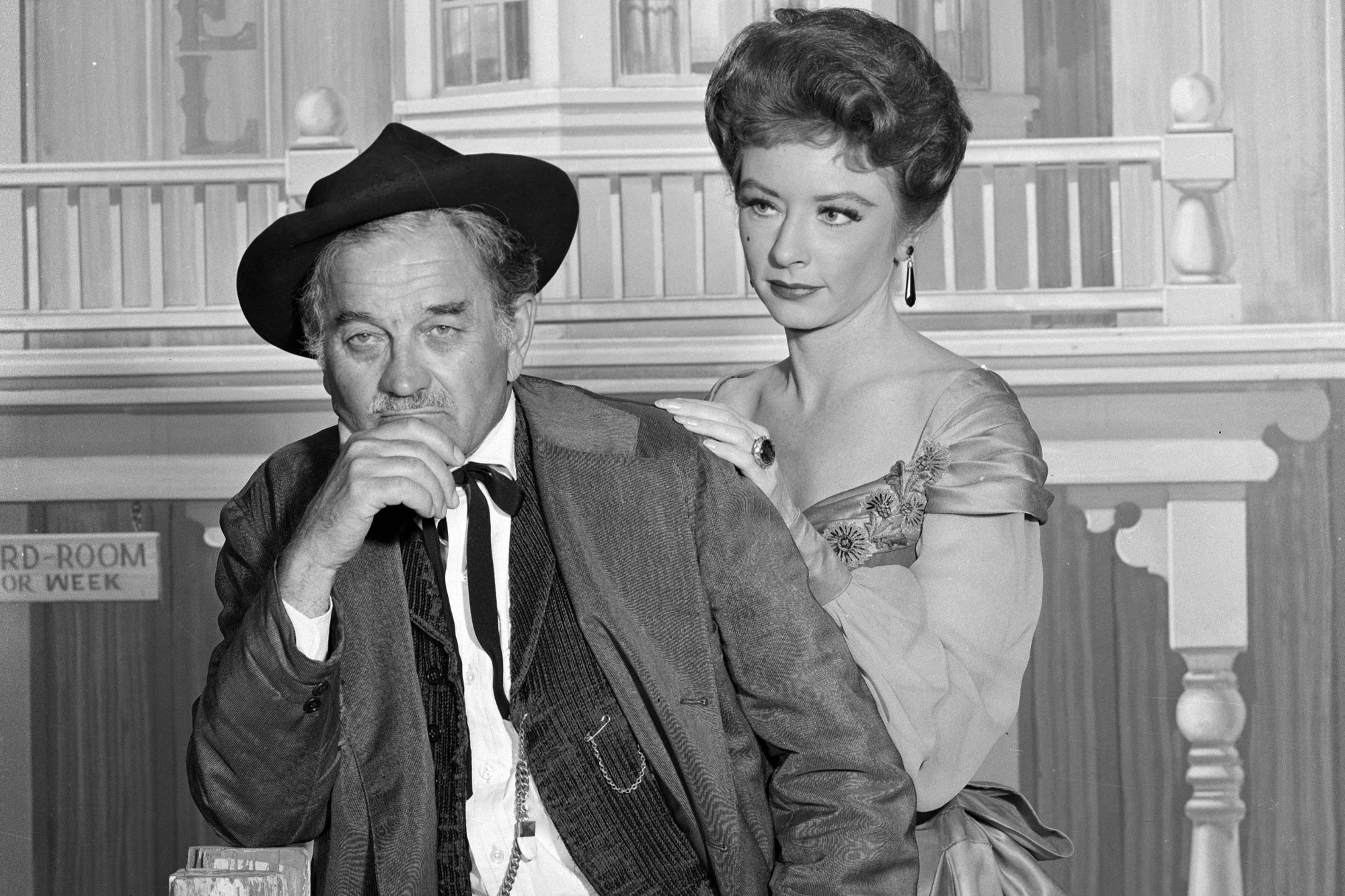 'Gunsmoke' Milburn Stone as Doc Adams and Amanda Blake as Miss Kitty Russell in a black-and-white picture in front of Long Branch saloon.