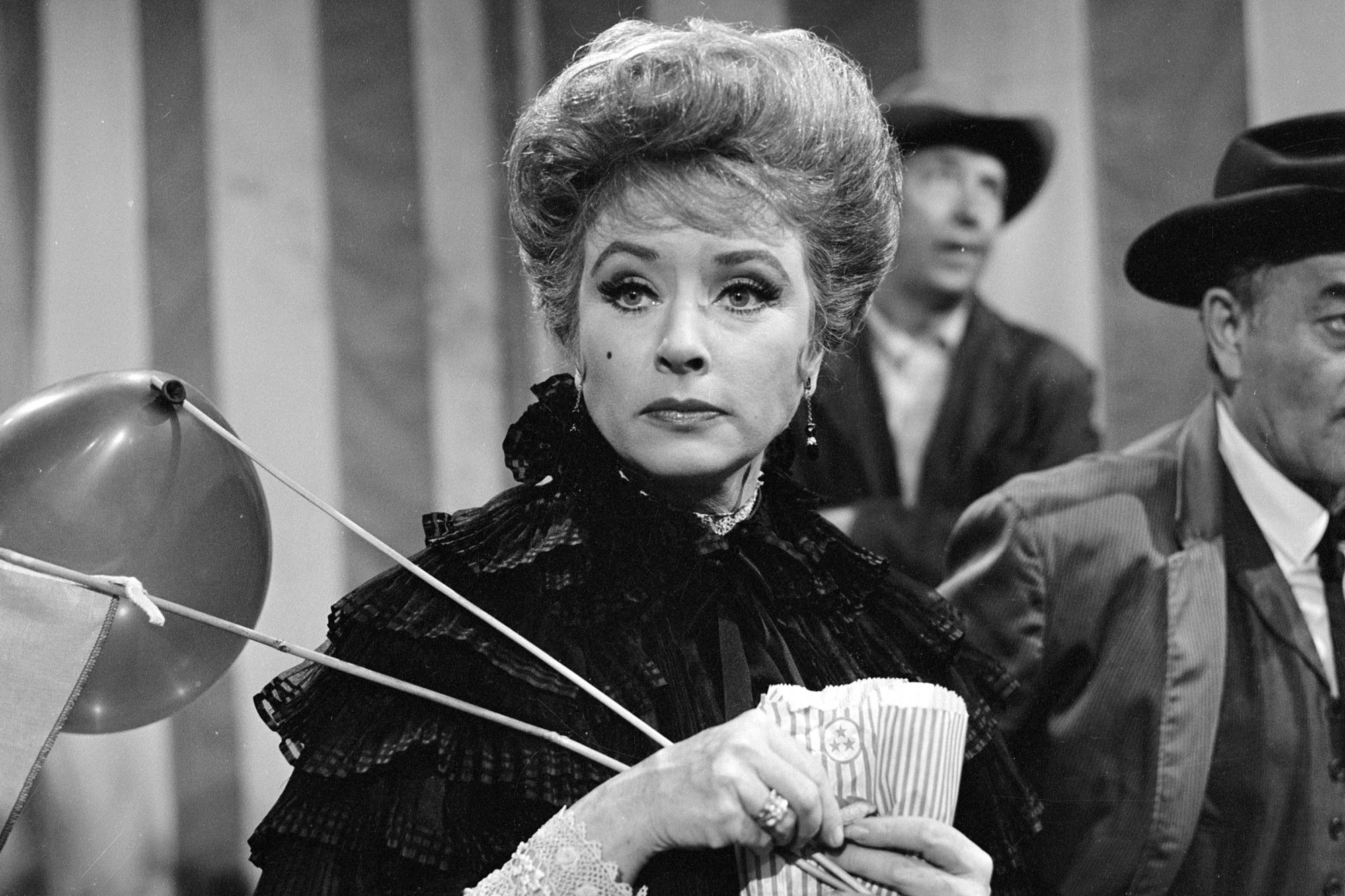 'Gunsmoke' actor Amanda Blake as Kitty Russell looking surprised holding a balloon at the circus