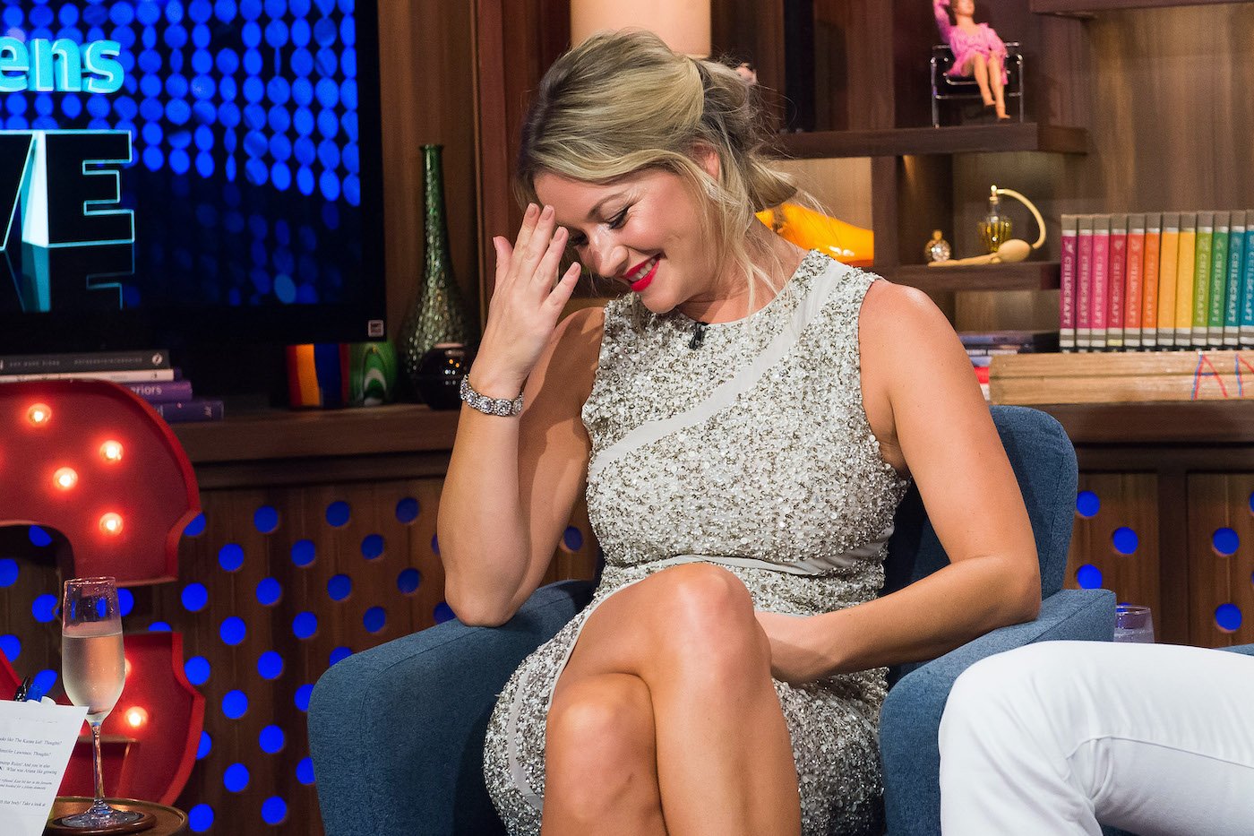 Hannah Ferrier from 'Below Deck Med' sits in a chair at 'WWHL' and looks down while smiling 