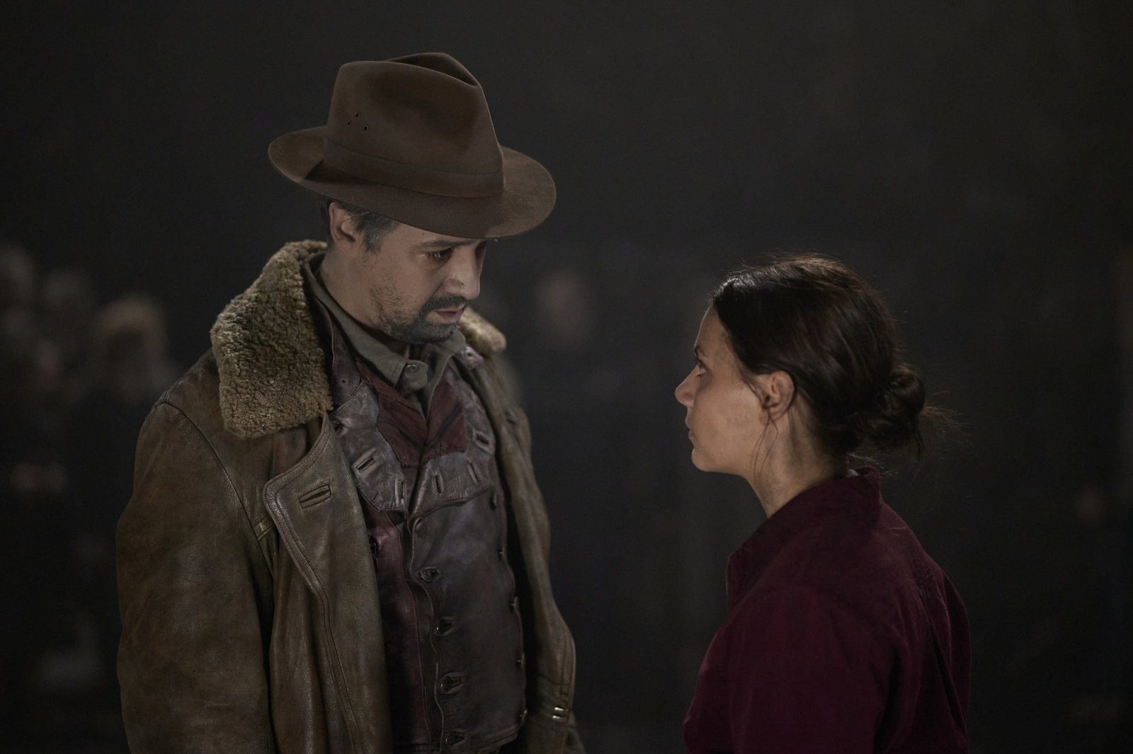 Lin-Manuel Miranda and Dafne Keen as Lee and Lyra in 'His Dark Materials' for our article about season 3, episodes 5 and 6. Lee is wearing a hat and looking down at Lyra, and she's staring up at him.