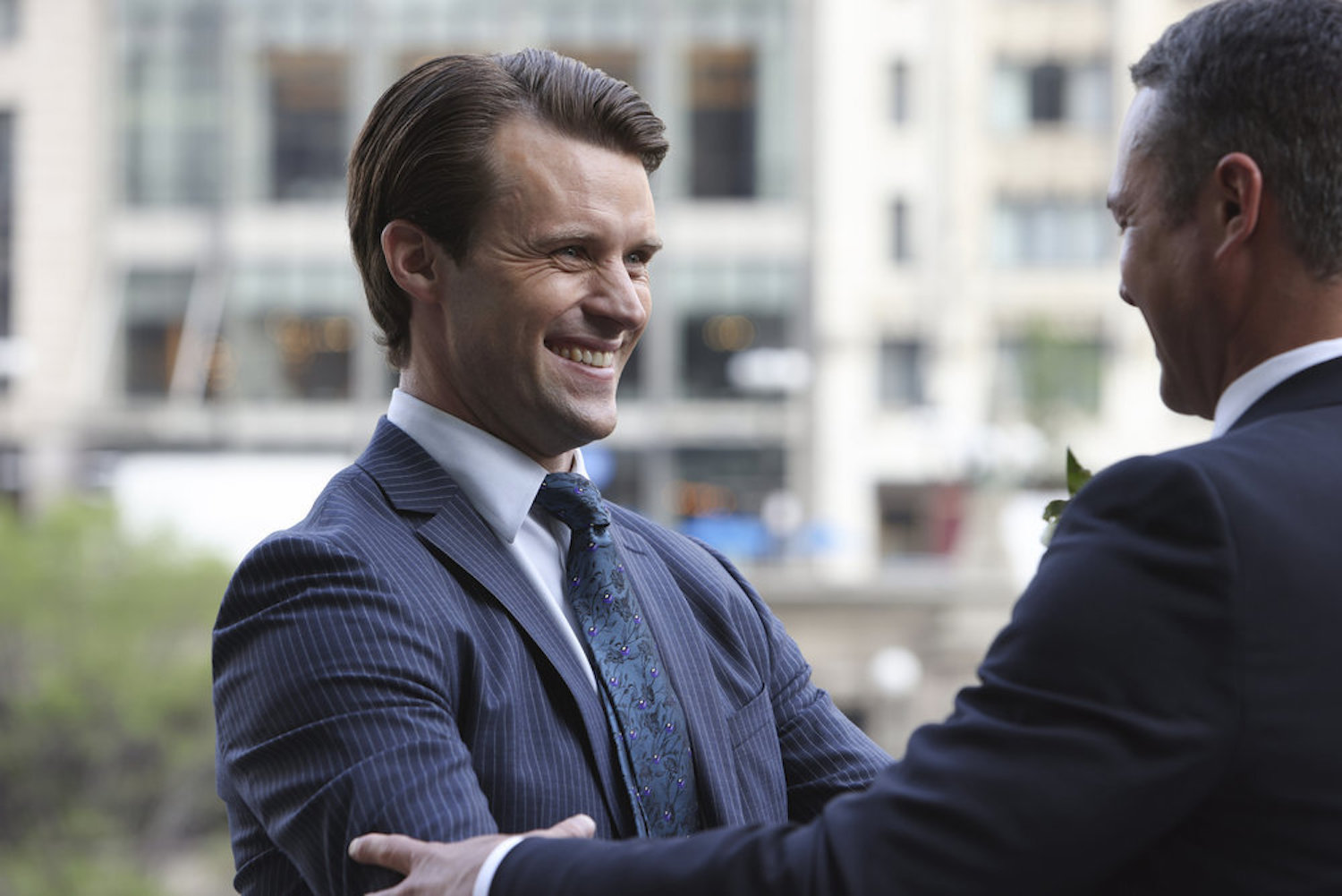 Matt Casey in a blue suit smiling in 'Chicago Fire'