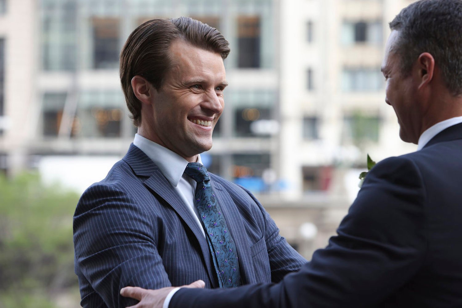 Matt Casey in a blue suit smiling in 'Chicago Fire'