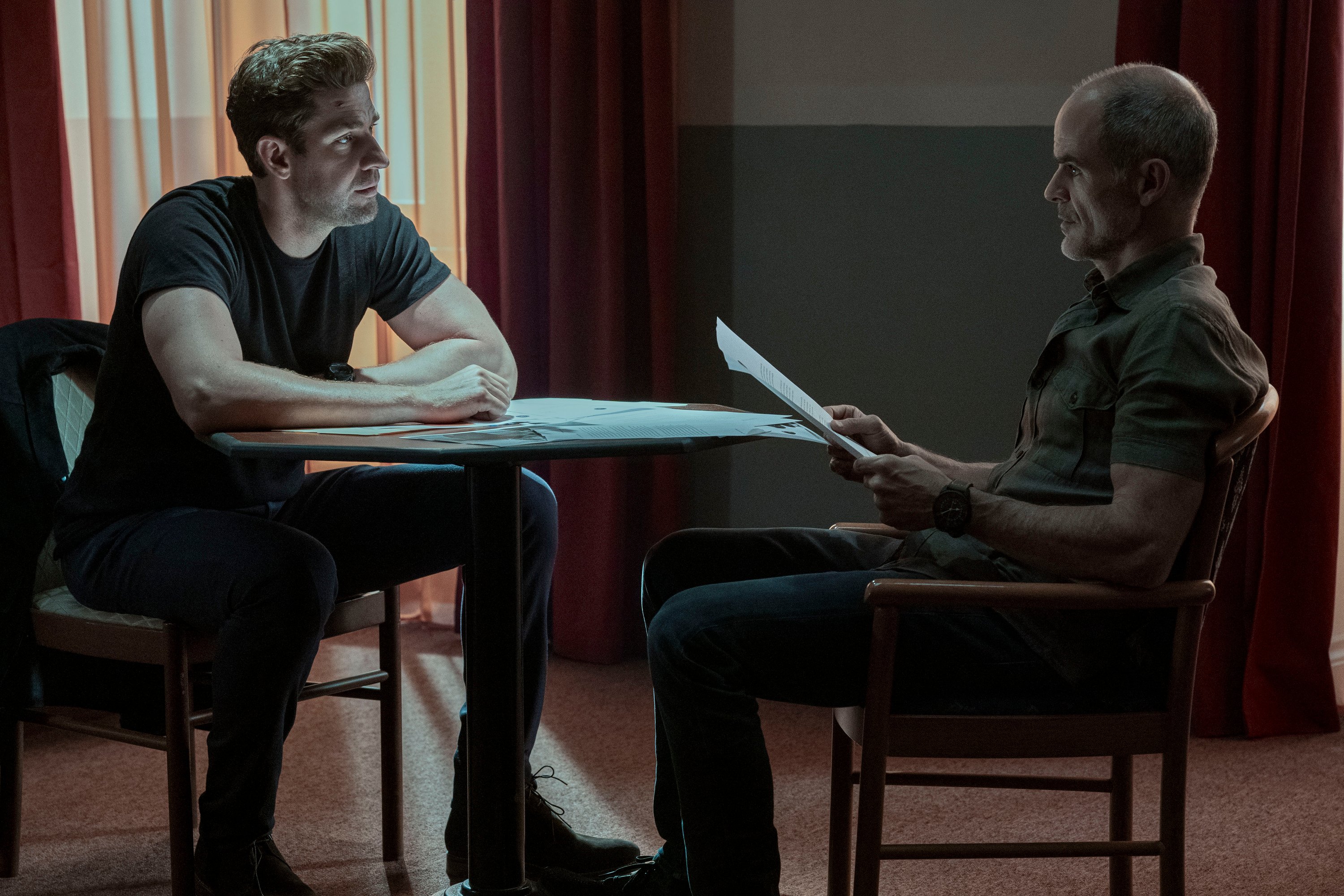 John Krasinski and Michael Kelly sitting across from each other in 'Jack Ryan' Season 3
