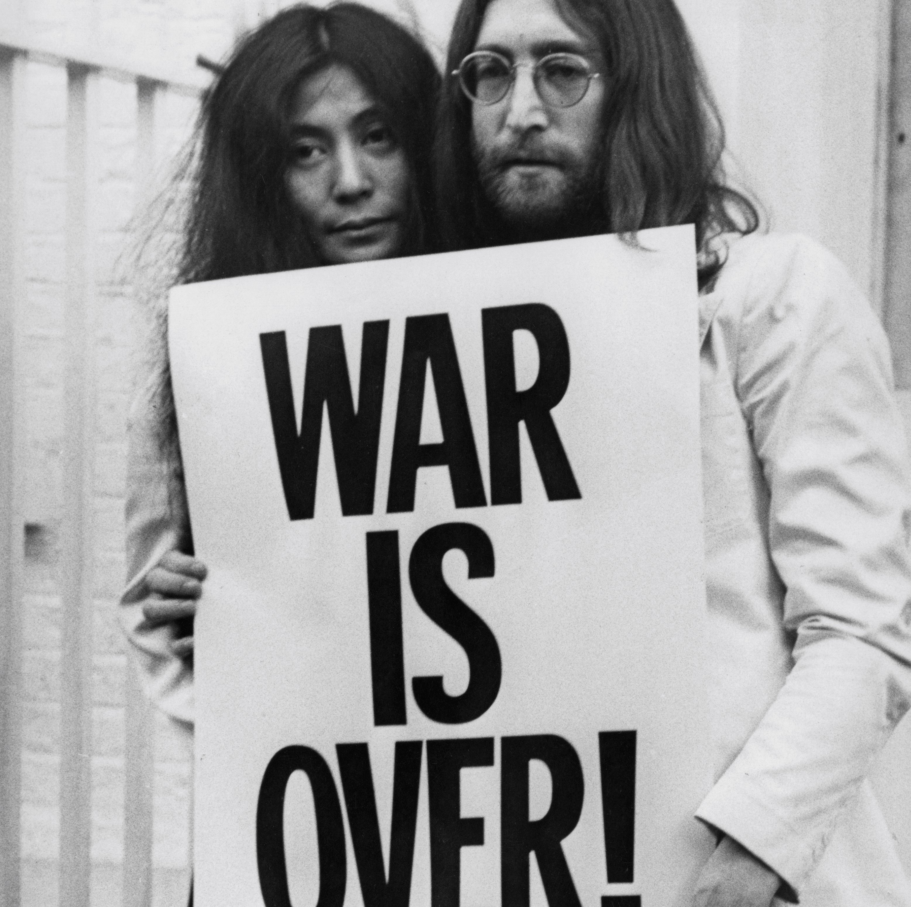 Yoko Ono and John Lennon with a 'War Is Over" sign