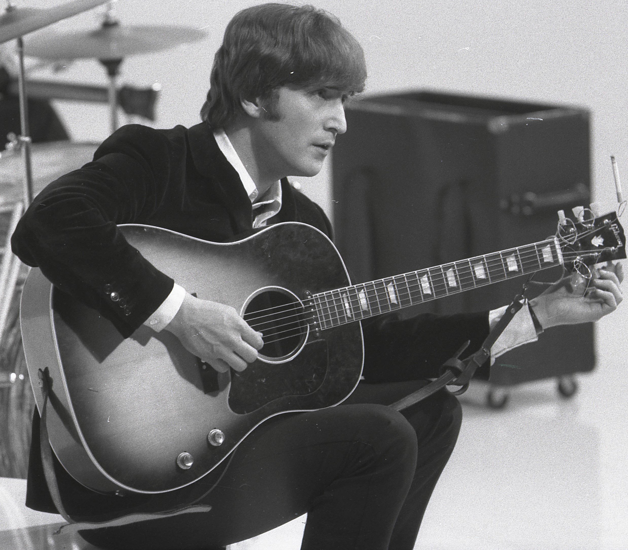 The Beatles' John Lennon holding a guitar