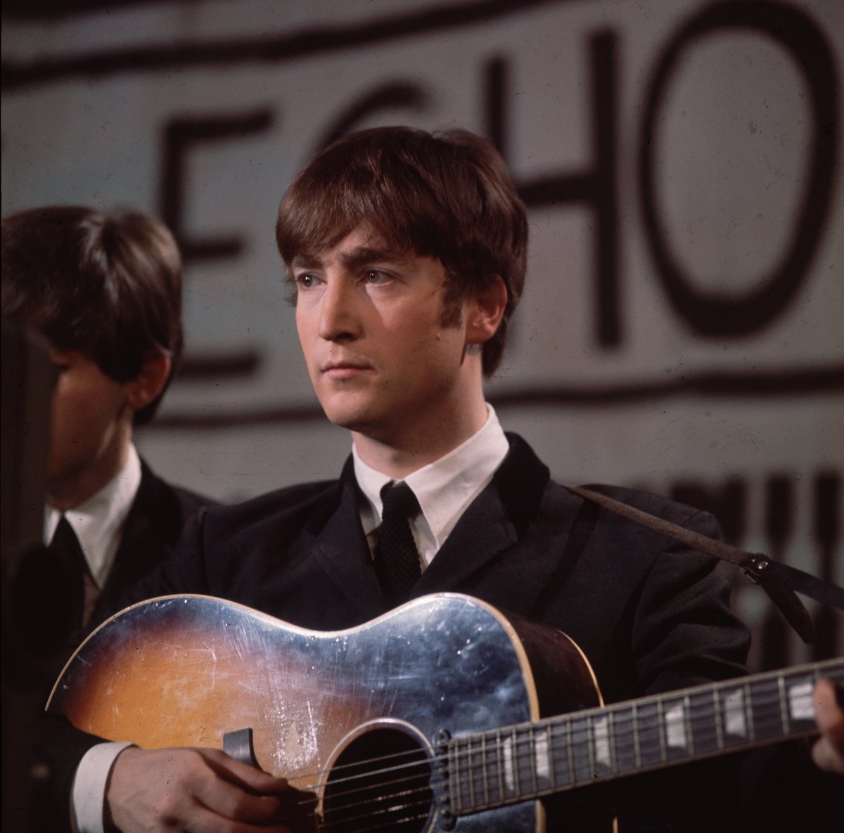 John Lennon plays guitar in The Beatles