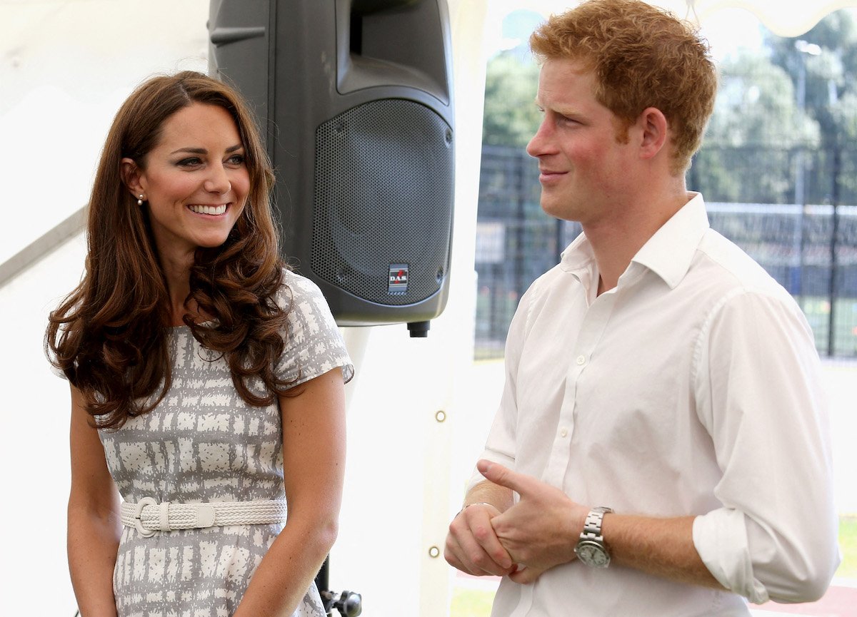 Kate Middleton and Prince Harry smile together at an event.