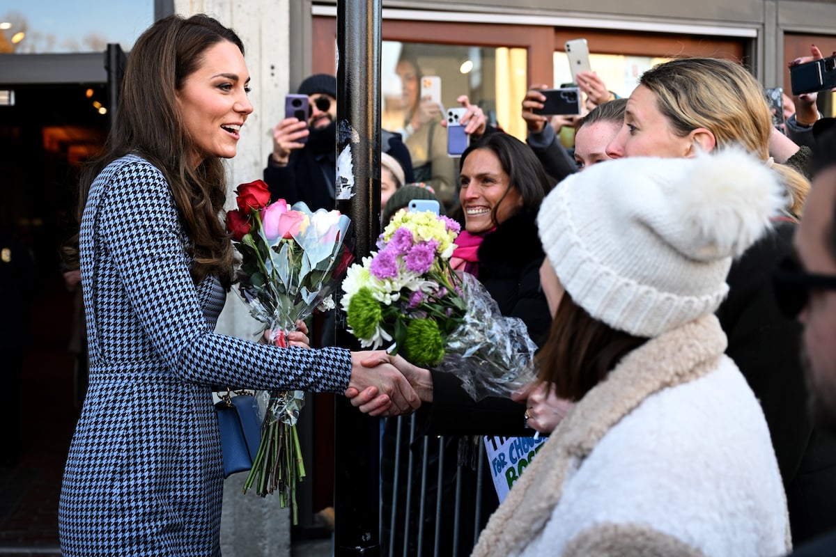 Kate Middleton, who Prince Harry and Meghan Markle — and their Netflix docuseries 'Harry & Meghan' — aren't going to take 'down' her and Prince William, according to a commentator by greeting fans, shakes someone's hand while visiting Harvard University