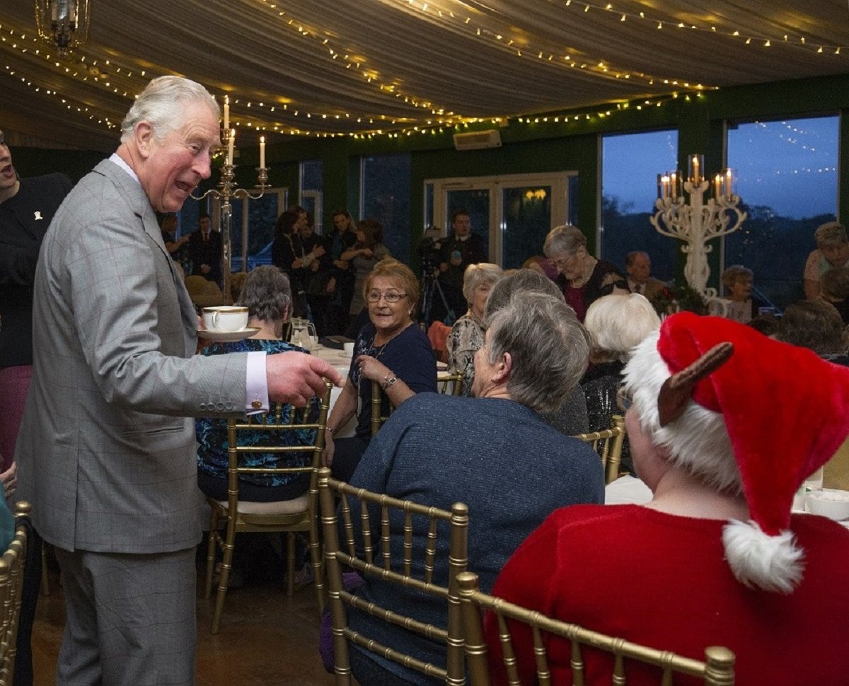 King Charles III laughing during a surprise visit to the Christmas tea dance at Dumfries House in Scotland