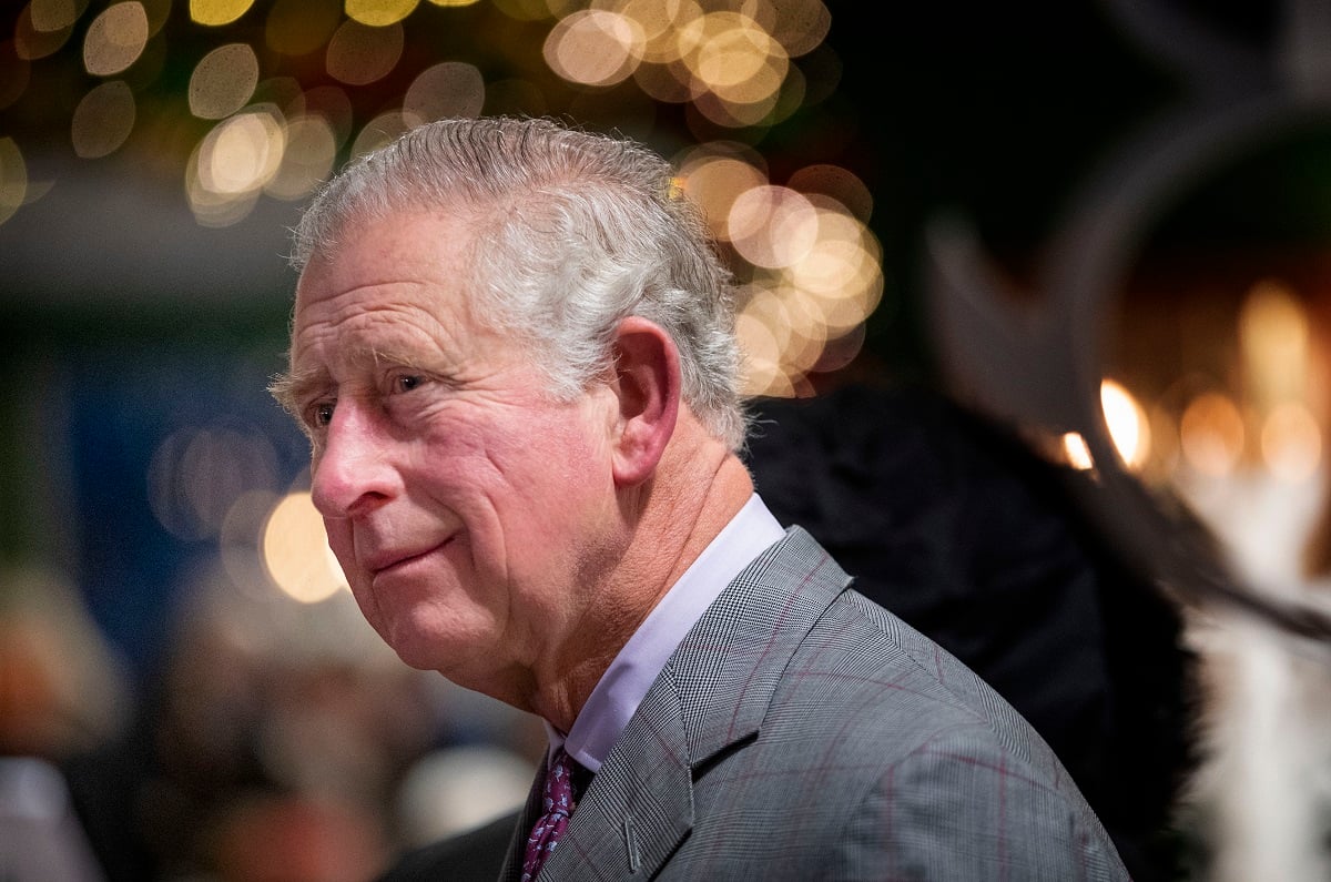 King Charles III, who is changing one of Queen Elizabeth II's Christmas traditions this year, smiling slightly during a surprise visit to the Christmas tea dance at Dumfries House in Scotland