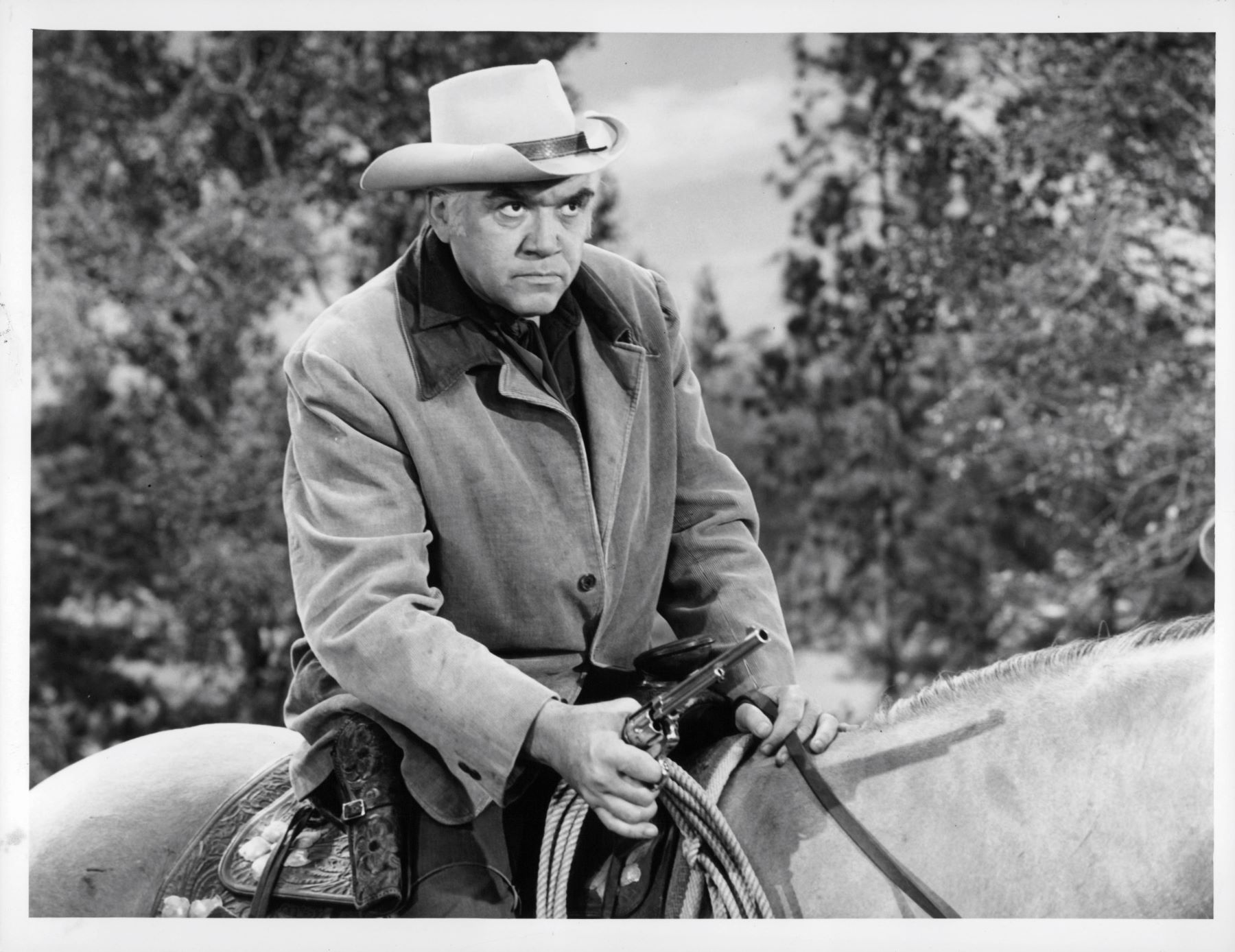 Actor Lorne Greene riding a horse on the set of 'Bonanza'