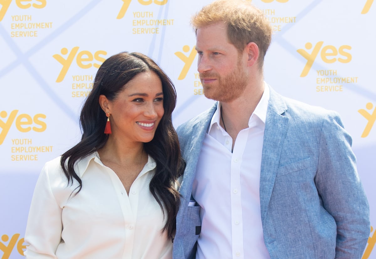 Meghan Markle and Prince Harry, who looked like an 'A-list power couple' in their 2019 Christmas card with their son, Archie Harrison Mountbatten-Windsor, according to a body language expert, smile as they stand next to each other