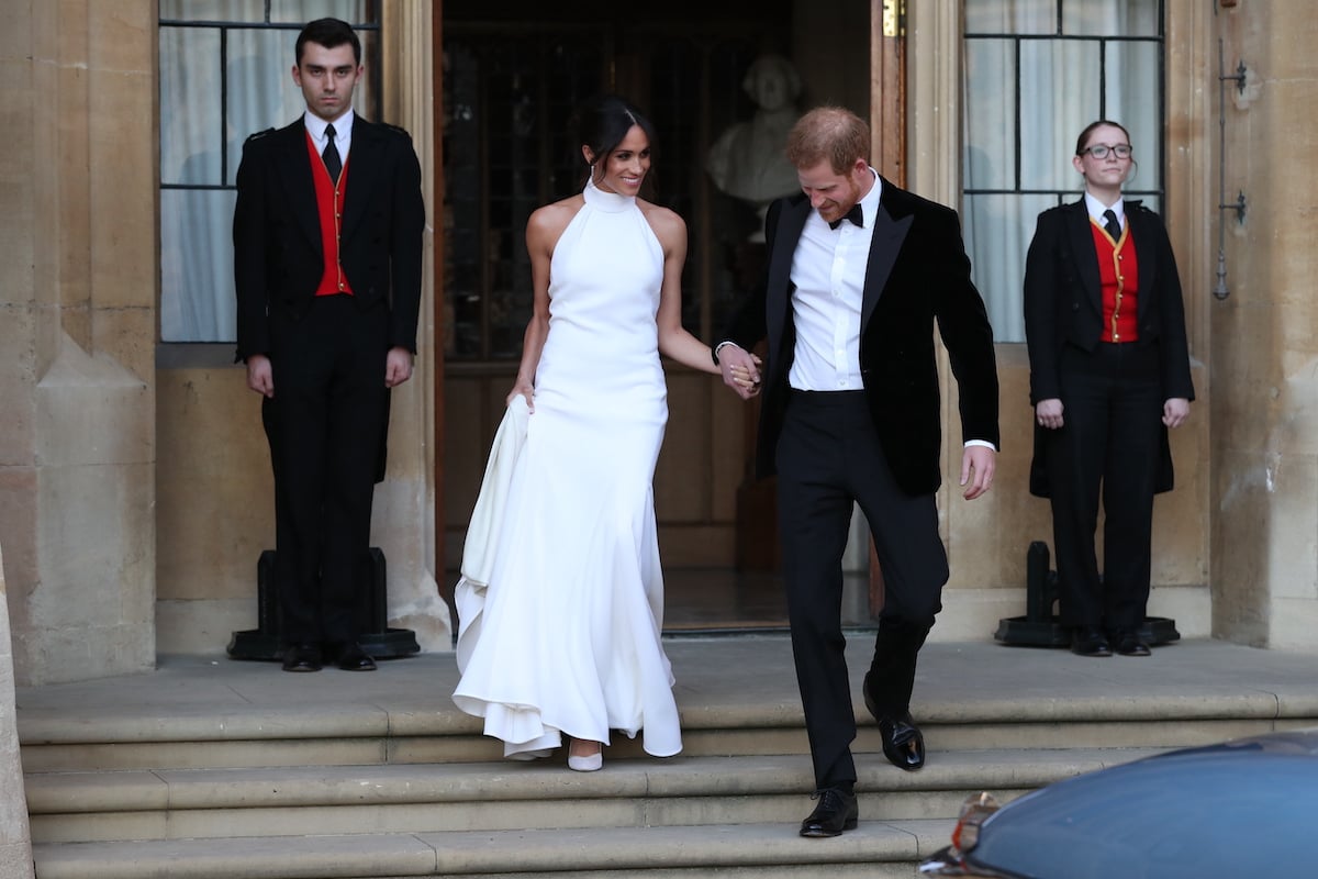 Meghan Markle, who said one line in her royal wedding speech got a 'big laugh' from guests in Netflix's 'Harry & Meghan', holds hands with Prince Harry as they leave for their royal wedding reception at Frogmore House