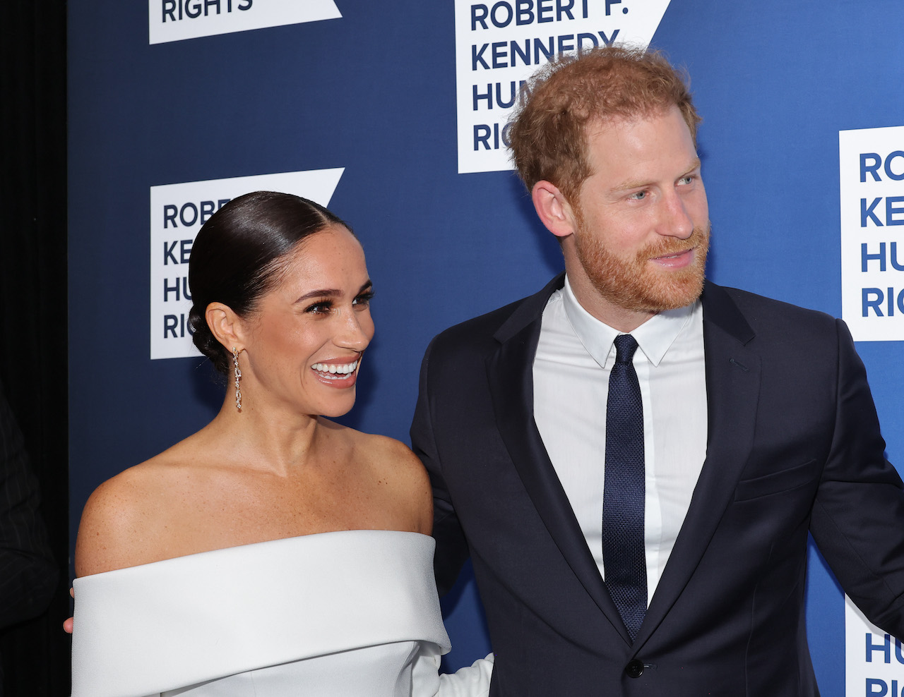 Meghan Markle and Prince Harry smile while attending event