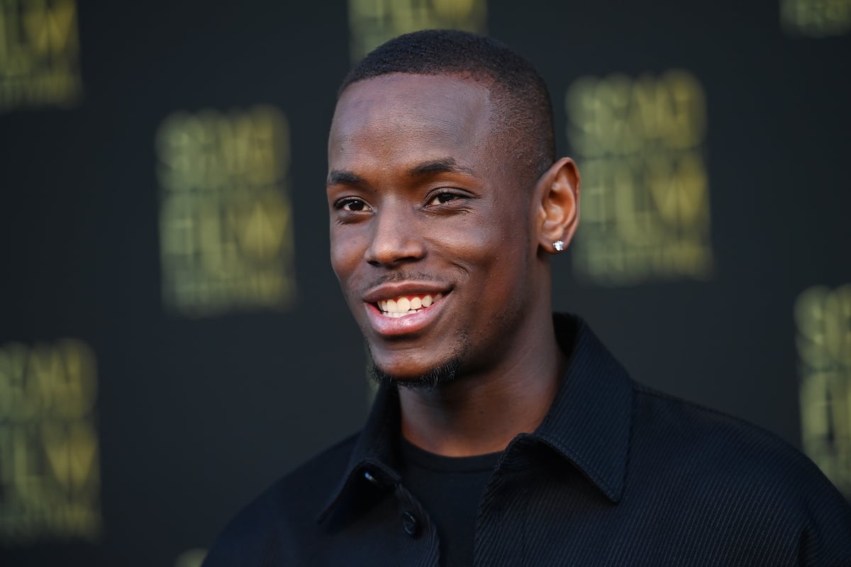 Michael Ward appears in front of a step and repeat at an event 