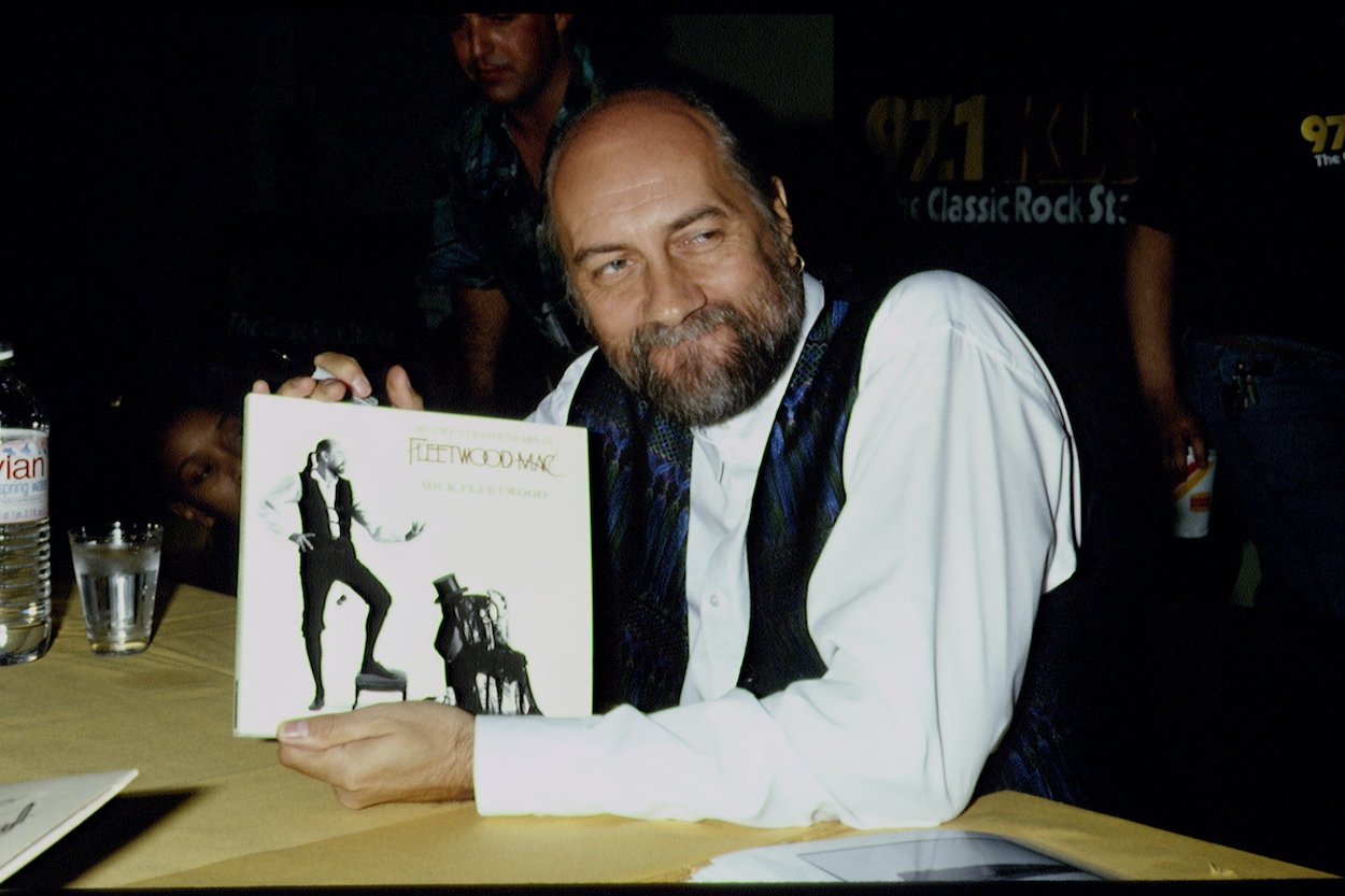 Mick Fleetwood holds a copy of his photo biography 'My 25 Years in Fleetwood Mac' in 1993. Fleetwood stole part of a toilet in the 1960s and made it worth $128,000 in 2022.