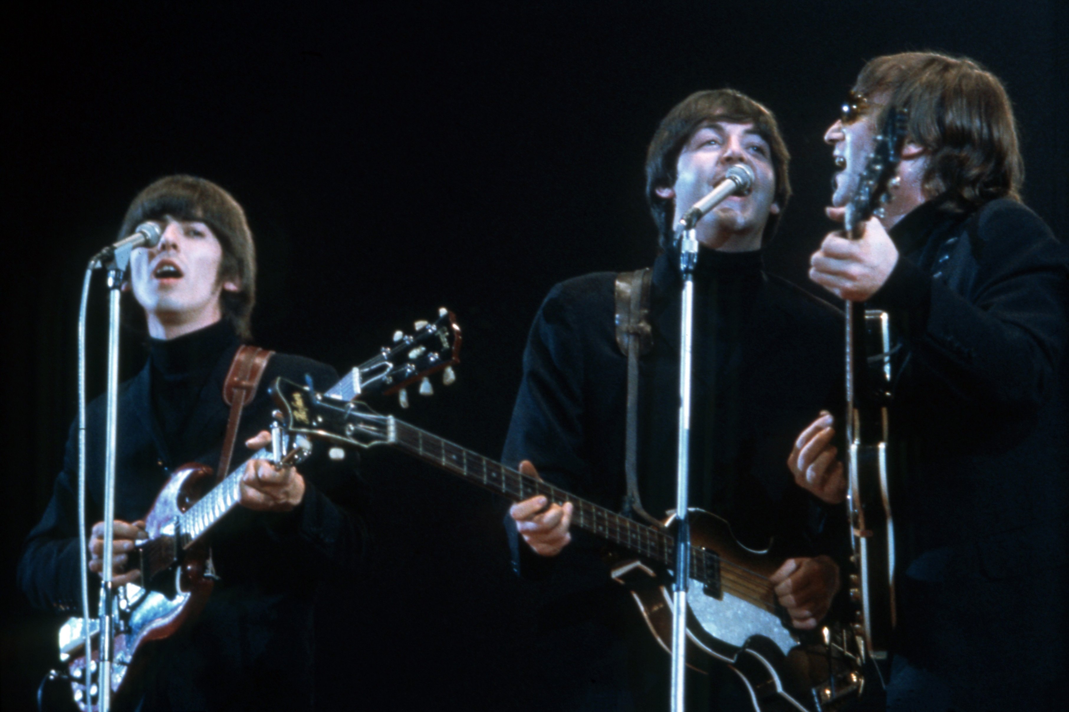George Harrison, Paul McCartney and John Lennon of The Beatles perform at Empire Pool in Wembley