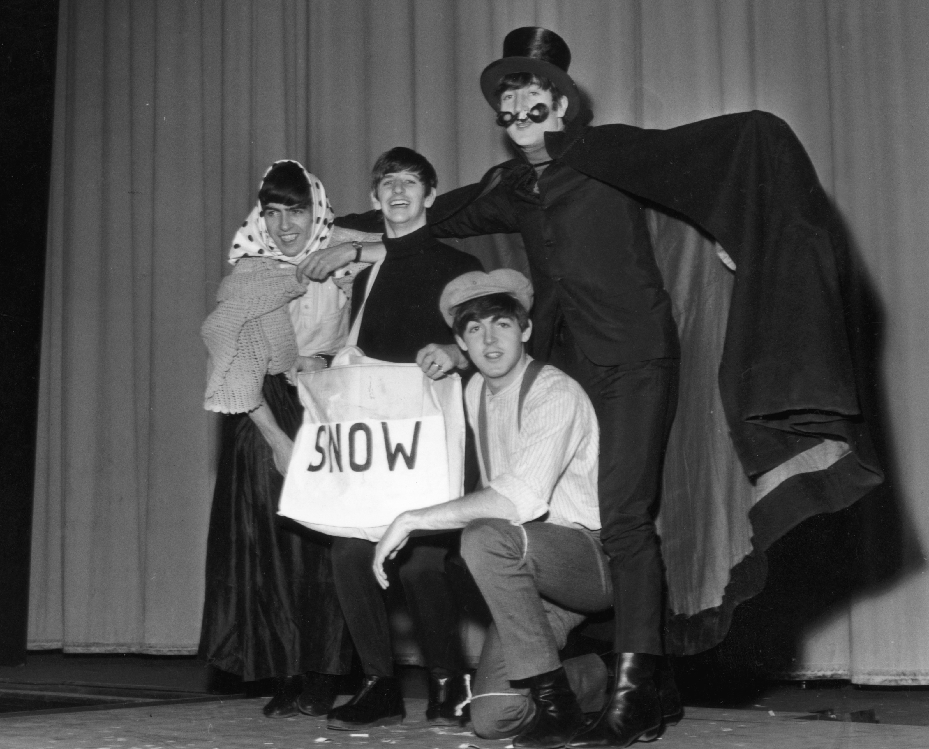 A black and white picture of George Harrison, Ringo Starr, Paul McCartney, and John Lennon dressed up for The Beatles' Christmas show.