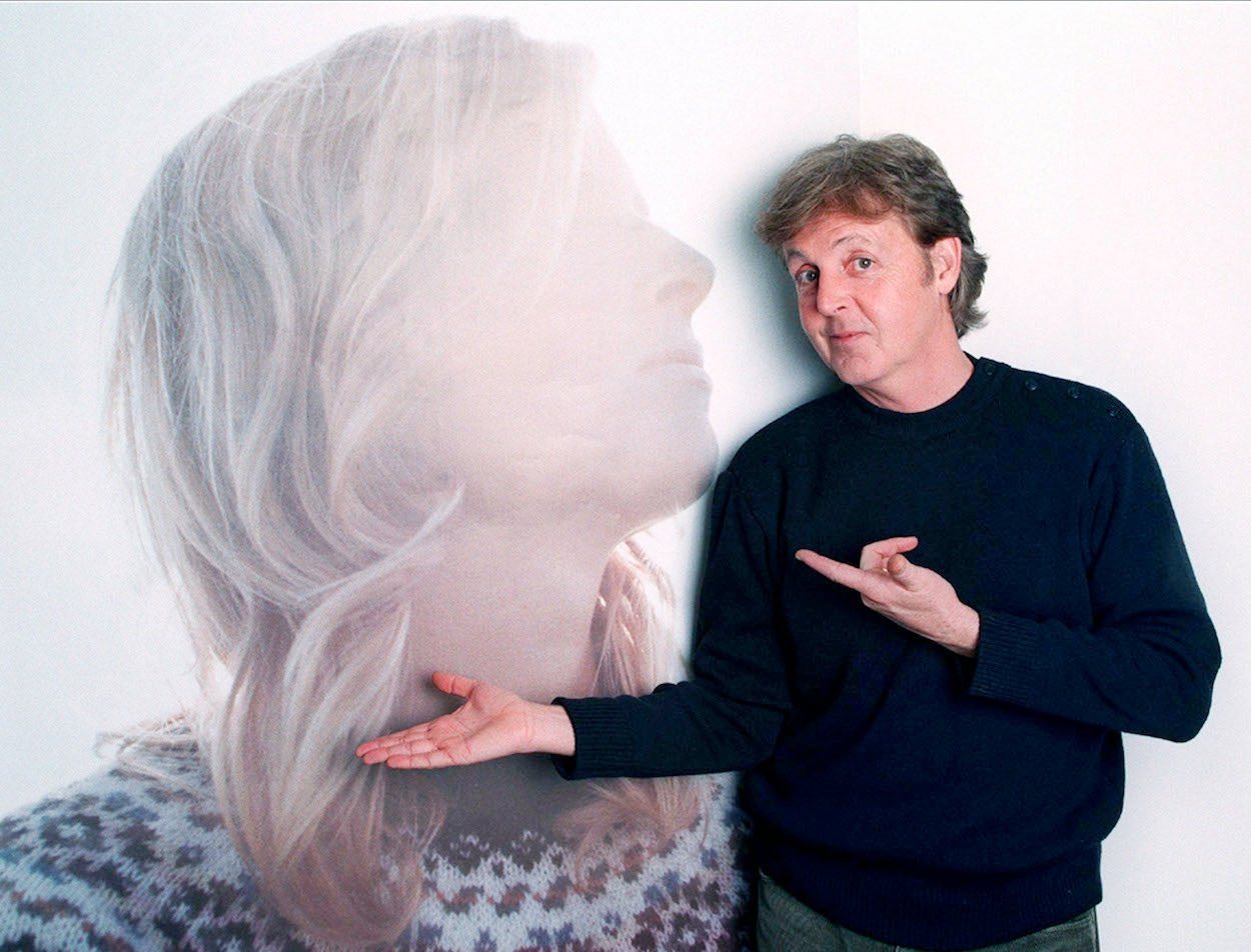 Paul McCartney stands in front of a photo of his wife Linda McCartney in November 1998, several months after her death.