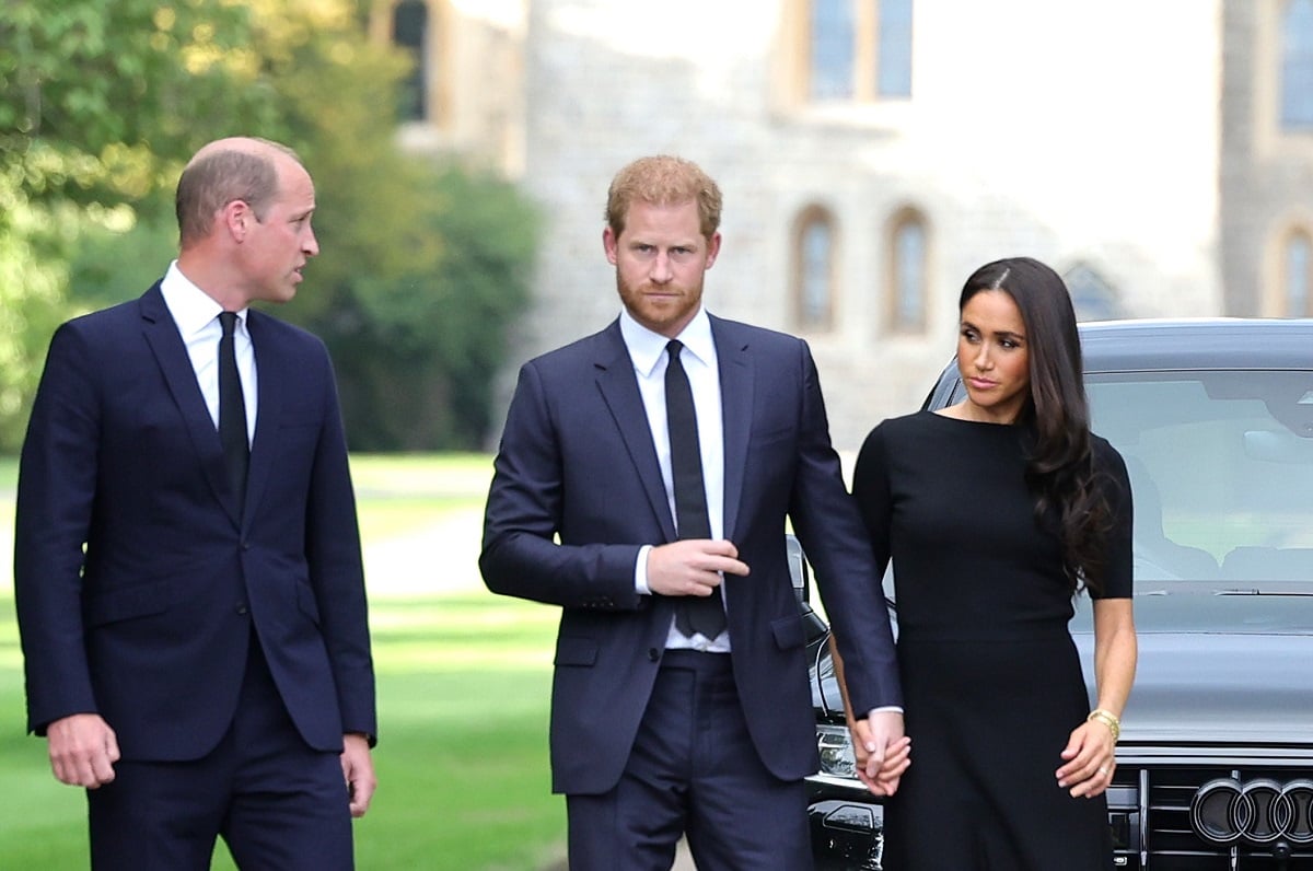 Prince William, Prince Harry, and Meghan Markle arrive on the Long Walk at Windsor Castle to view tributes to Queen Elizabeth II