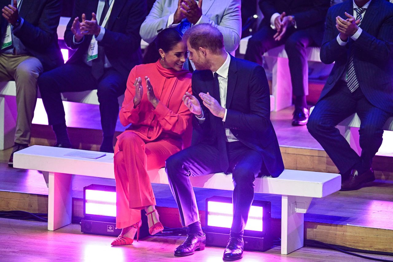Meghan Markle, Duchess of Sussex, and 'besotted' Prince Harry, Duke of Sussex, speak together as they applaud while attending the annual One Young World Summit at Bridgewater Hall in Manchester, north-west England, on September 5, 2022.