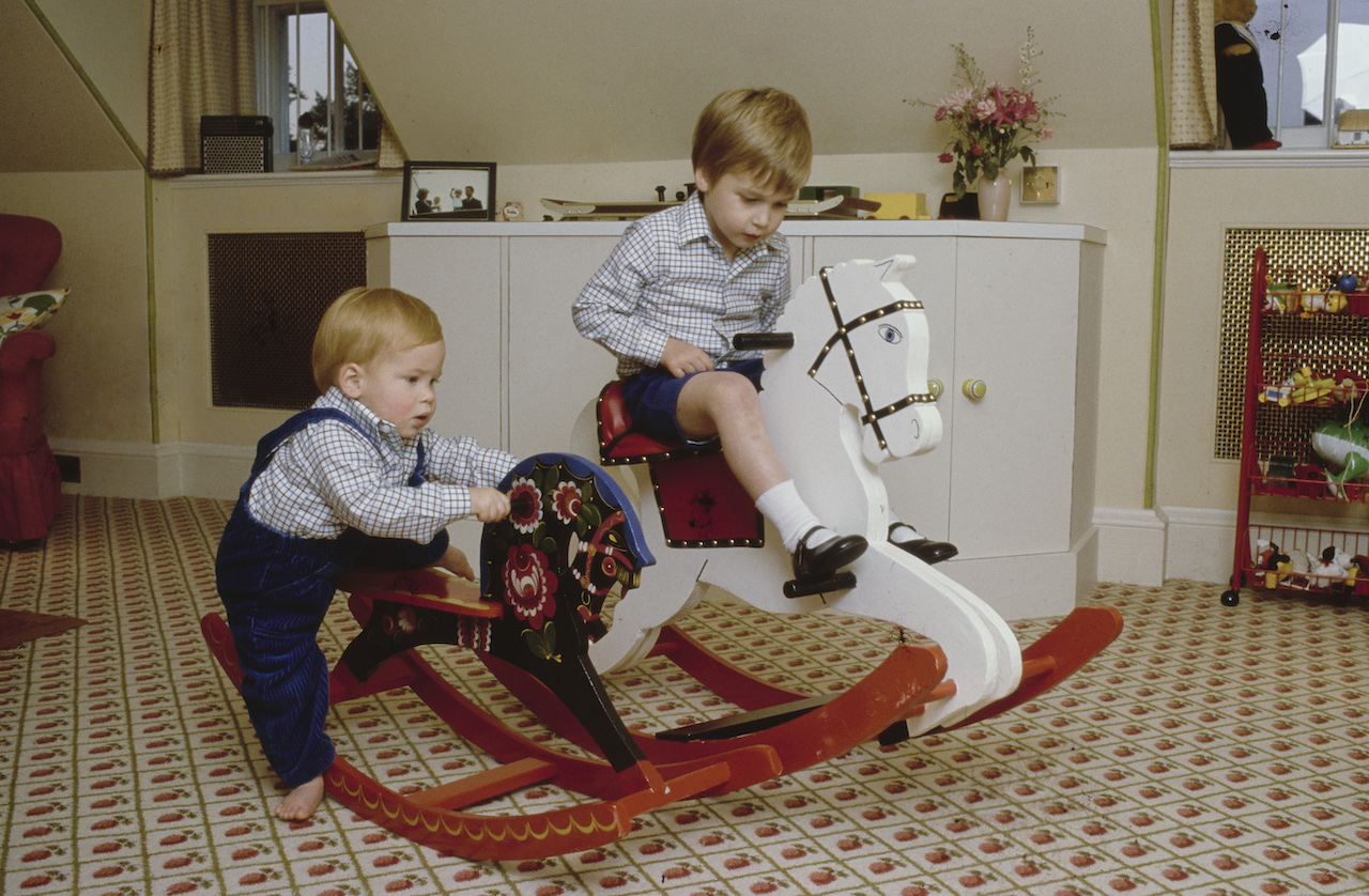 Prince Harry and Prince William play on a rocking horse at their home in Kensington Palace, London, England, 22nd October 1985.