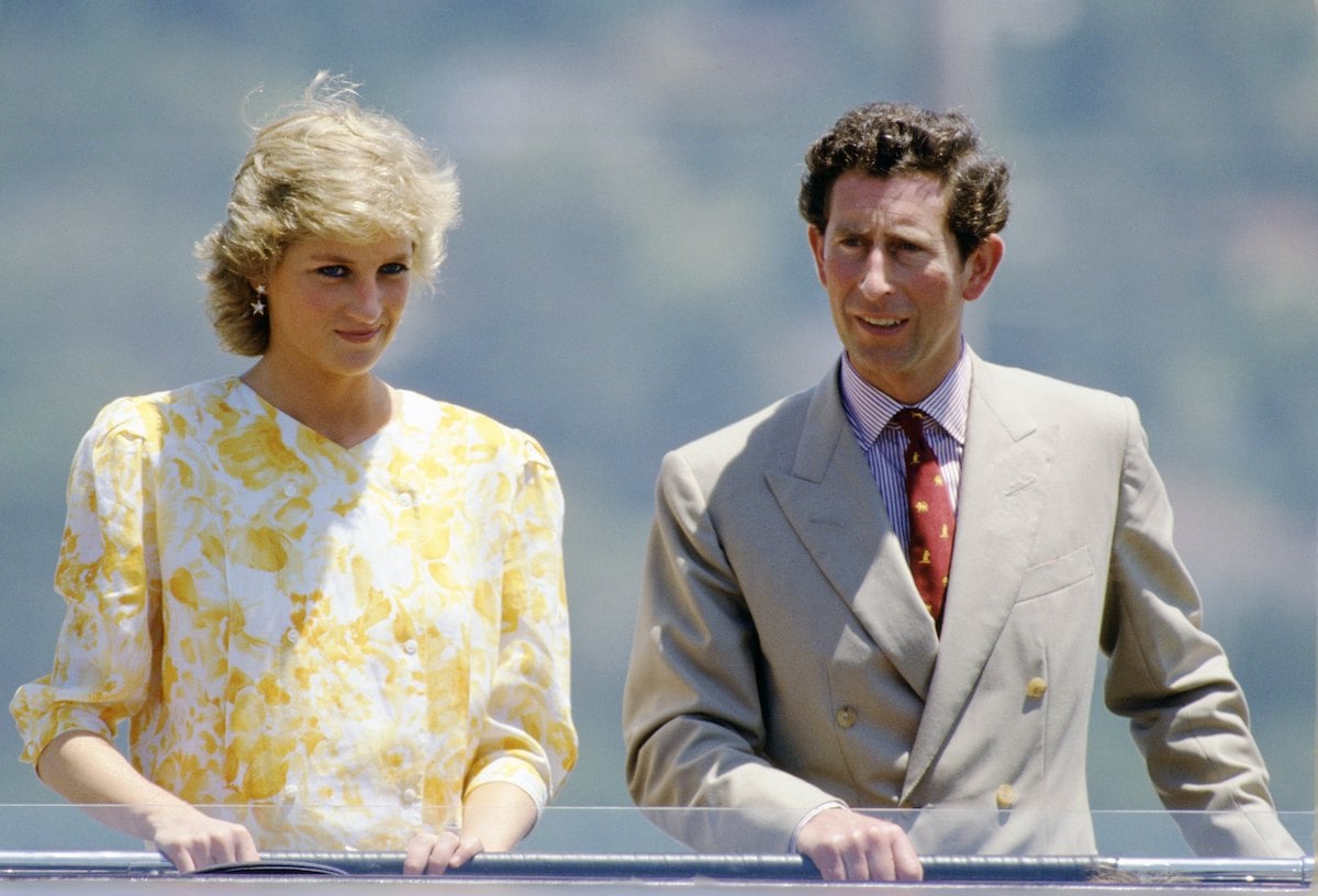 Princess Diana and King Charles, who looked like a 'sore loser' after Princess Diana's 'legendary' piano performance during a 1988 royal tour of Australia, according to a body language expert, stand next to each other and look on while in Australia