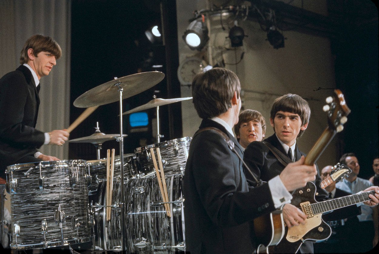Beatles drummer Ringo Starr (left) sits on his drum riser as Paul McCartney, John Lennon, and George Harrison perform on 'The Ed Sullivan Show' in 1964.