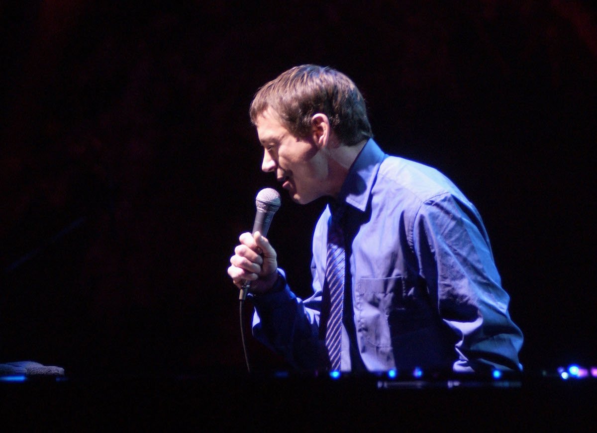 Robert Downey speaking into a microphone at an event in 2001.