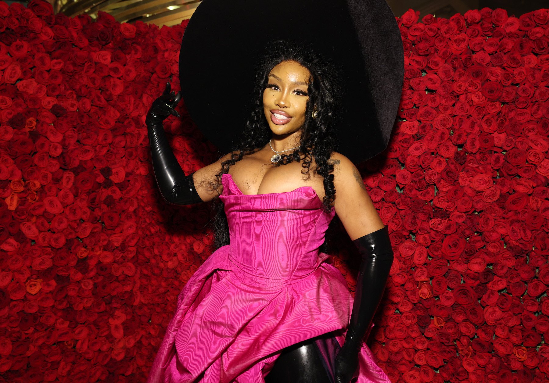 SZA, who admitted Princess Diana inspired her new album cover, posing for a photo wearing a black hat and pink dress