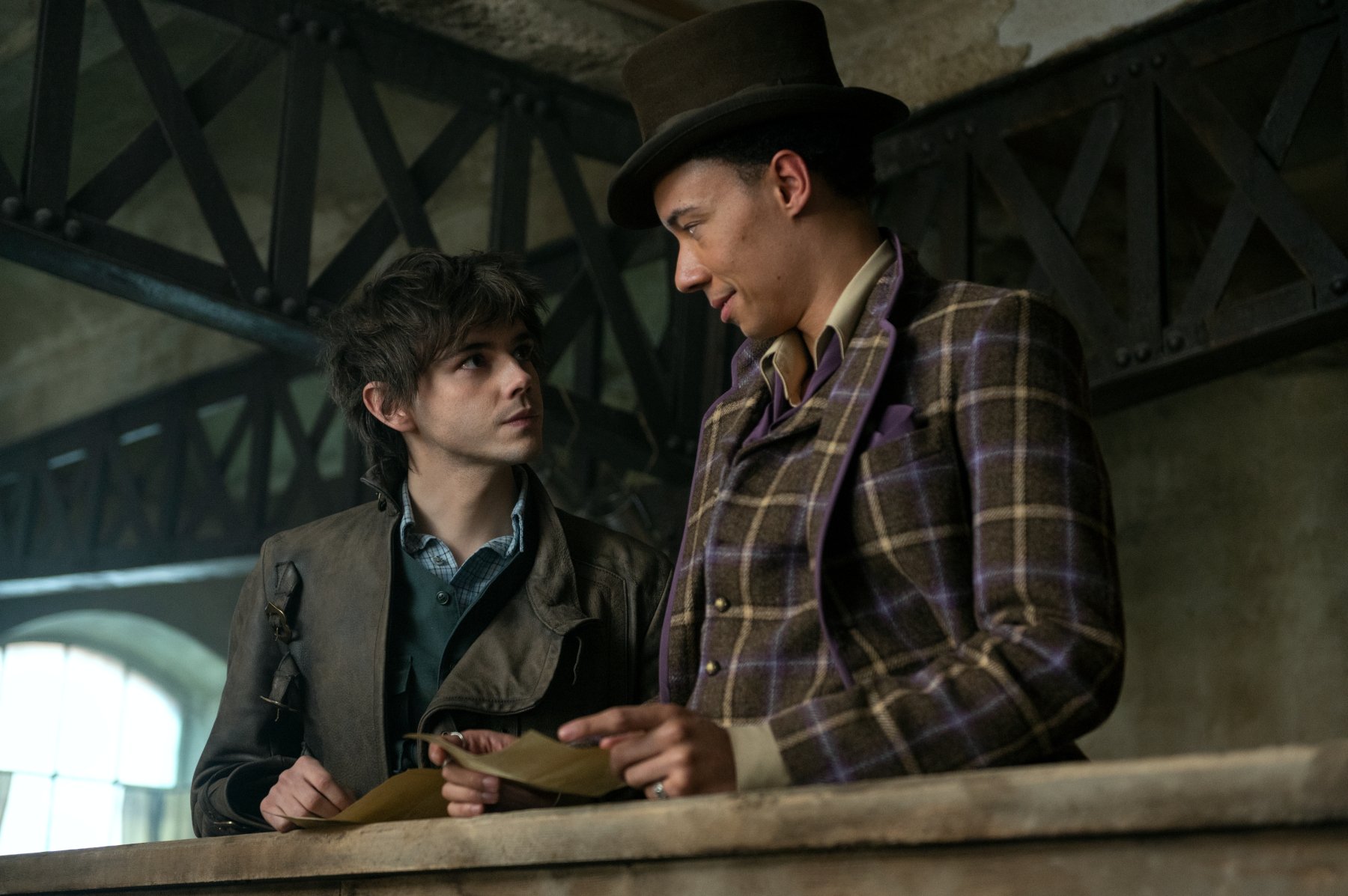 Jack Wolfe as Wylan and Kit Young as Jesper Fahey in 'Shadow and Bone' Season 2. They're staring at one another, and Jesper is smiling.