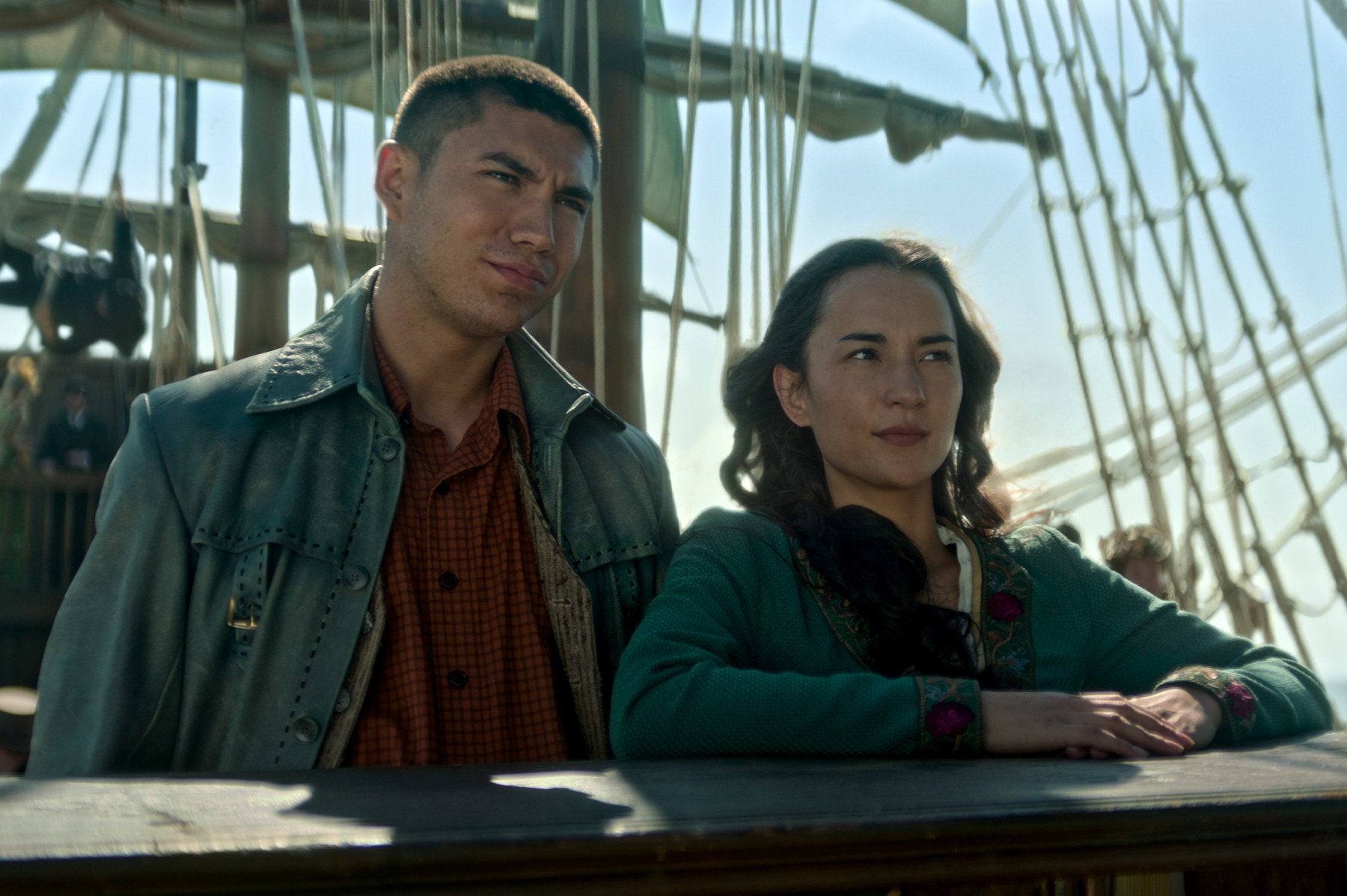 Archie Renaux and Jessie Mei Li in 'Shadow and Bone' Season 2 for our article about its release date. The two are standing aboard a ship and leaning on the edge.