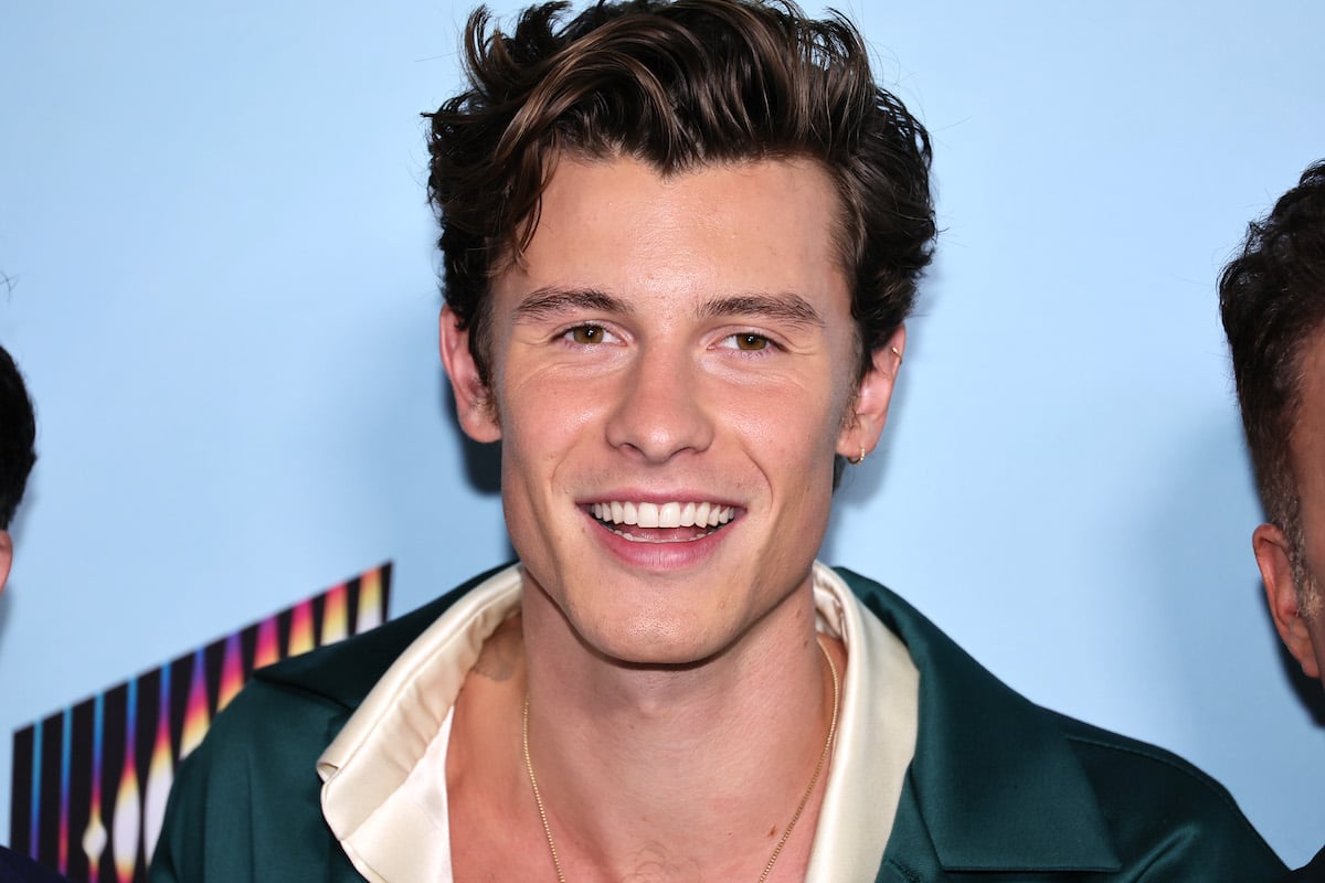 Shawn Mendes, who just bought a new house in Los Angeles, smiles and poses at an event.