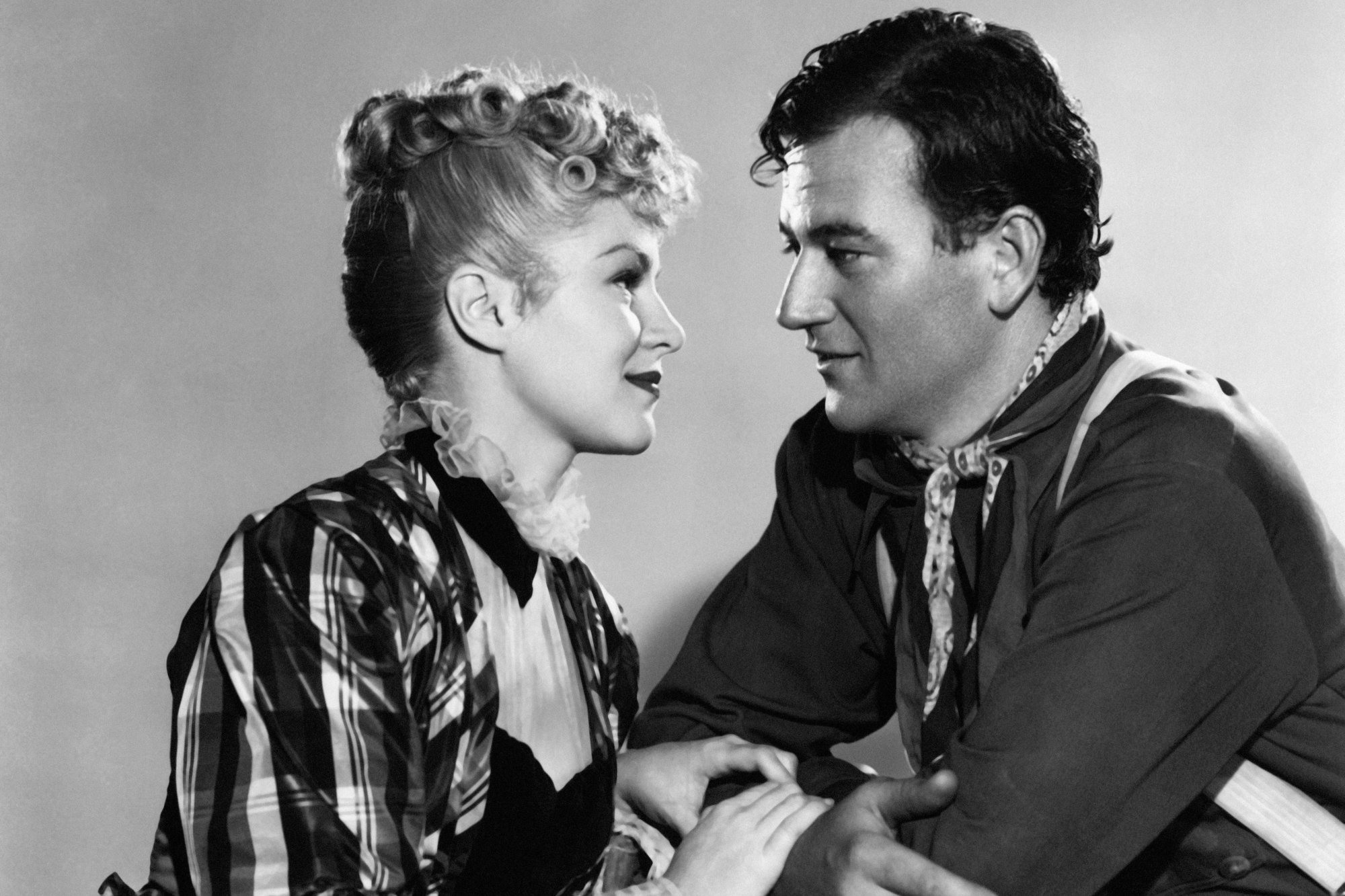 'Stagecoach' Claire Trevor as Dallas and John Wayne as Ringo Kid looking lovingly into one another's eyes in a black-and-white picture