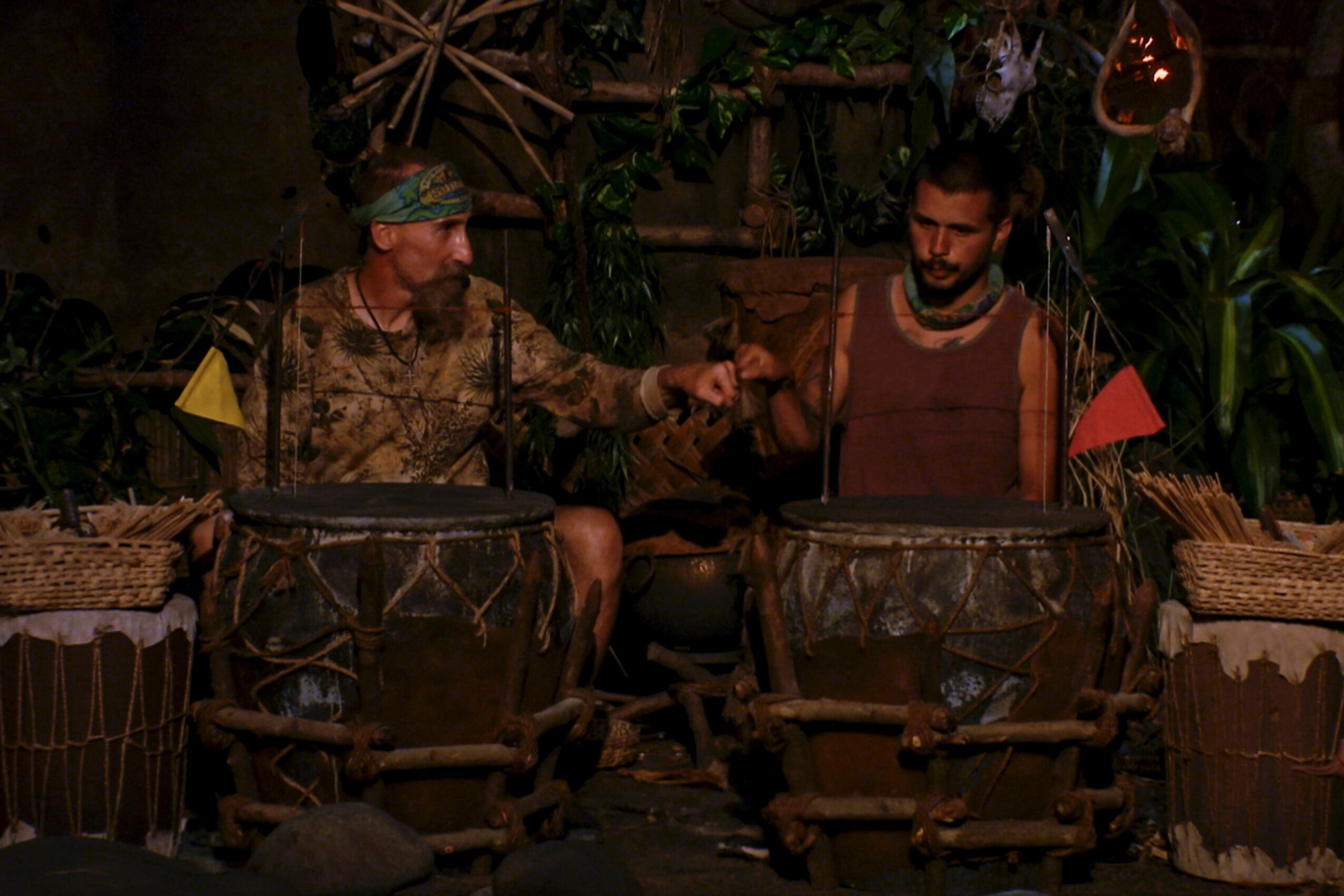 Mike Gabler and Jesse Lopez, who starred in 'Survivor' Season 43 on CBS, compete in the fire-making challenge. Gabler wears a camo shirt. Jesse wears a faded red tank top.