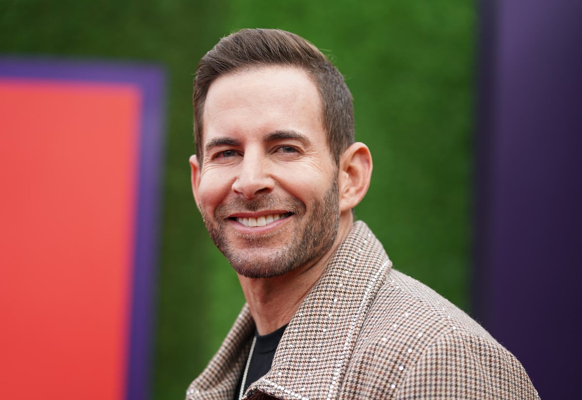 Tarek El Moussa, who recently described his work ethic, smiles and poses at an event.