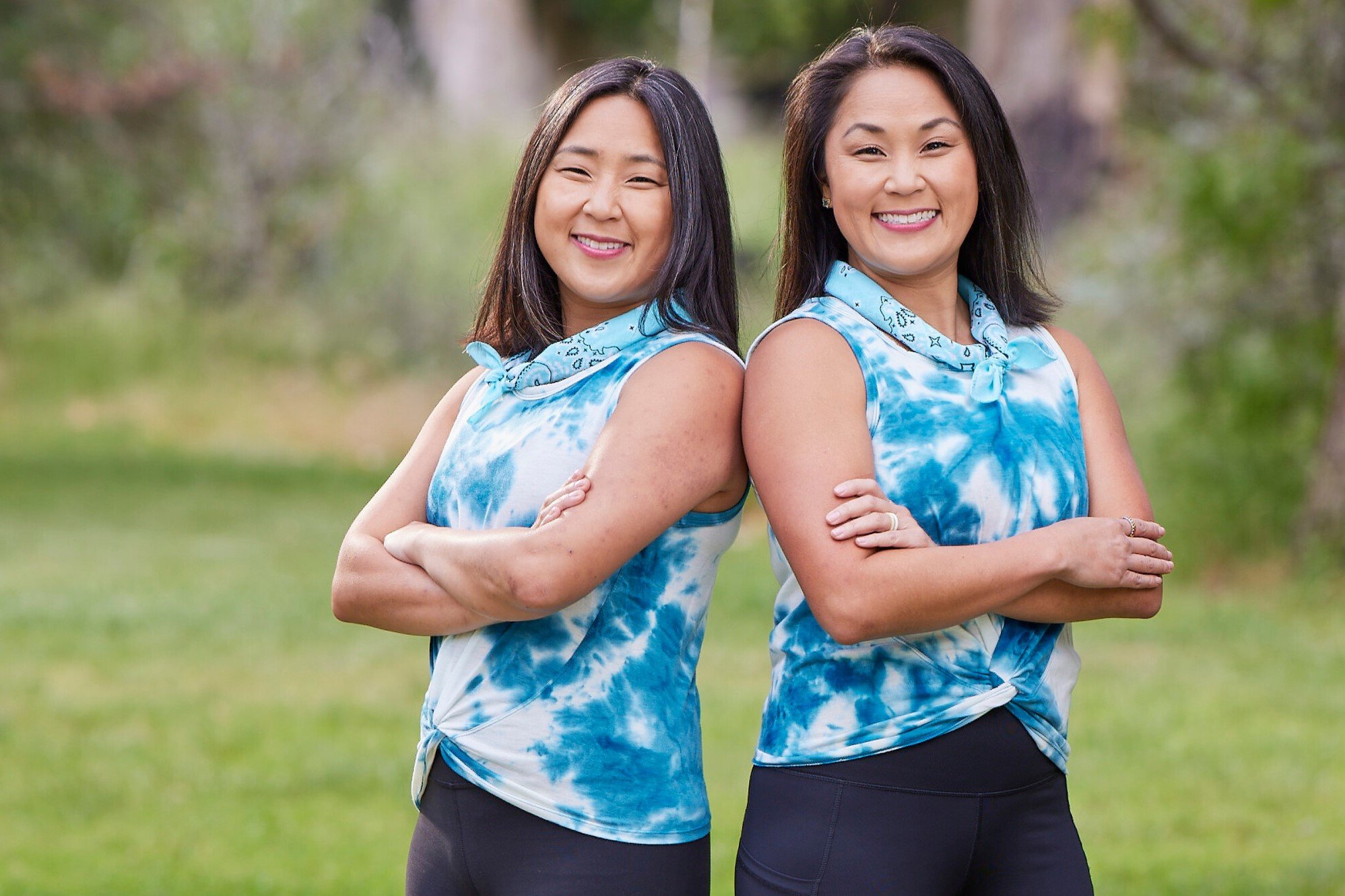 Emily Bushnell and Molly Sinert, who star in 'The Amazing Race 34' on CBS, pose for promotional pcitures. The twins weare the same blue and white tie dye tank top and black leggings.