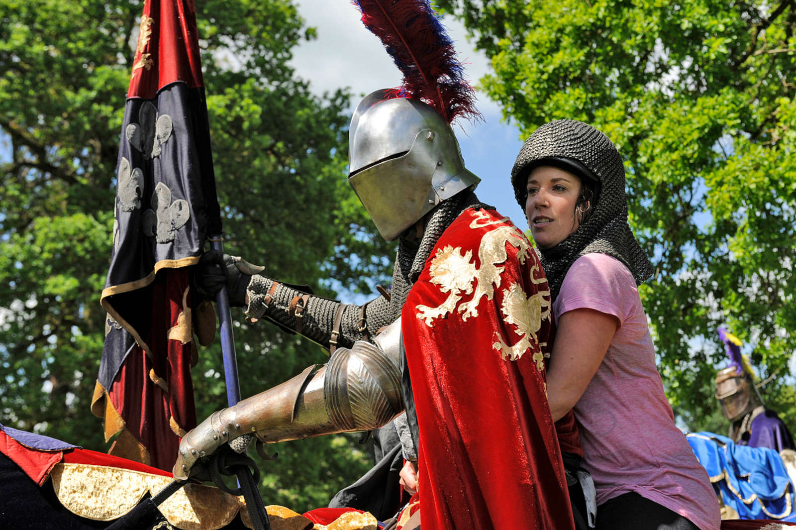 Claire Champlin in 'The Amazing Race' Season 17. She's riding on horseback with a knight.