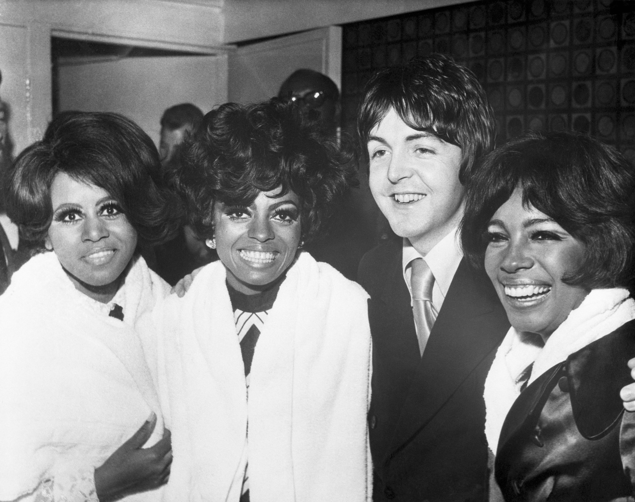 Paul McCartney of The Beatles poses with The Supremes at a party in London