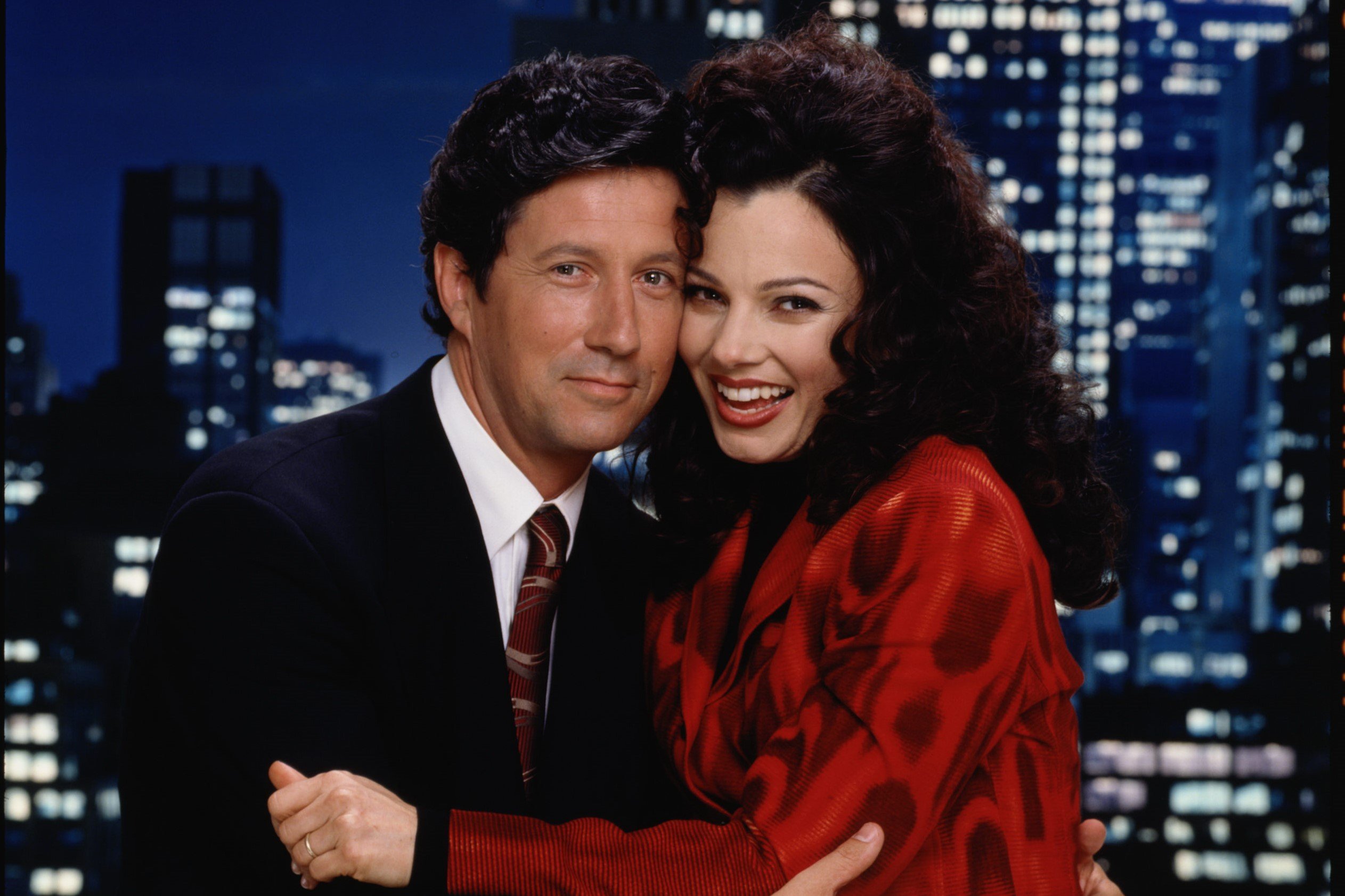 Charles Shaughnessy and Fran Drescher, in character as Maxwell Sheffield and Fran Fine in 'The Nanny,' which aired one Hanukkah episode in season 6. Maxwell wears a black suit, white button-up shirt, and maroon tie. Fran wears a red blazer.