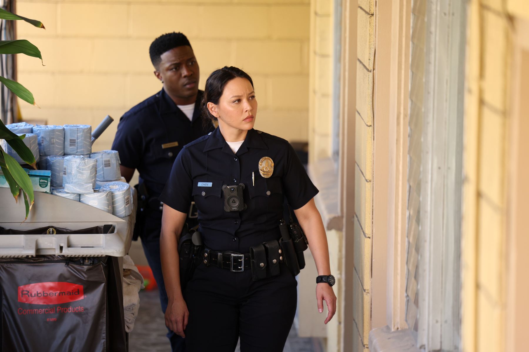 Tru Valentino and Melissa O'Neil, who star in 'The Rookie' Season 5 Episode 8 on ABC, share a scene as Aaron Thorsen and Lucy Chen, and they both are wearing their dark blue police uniforms.