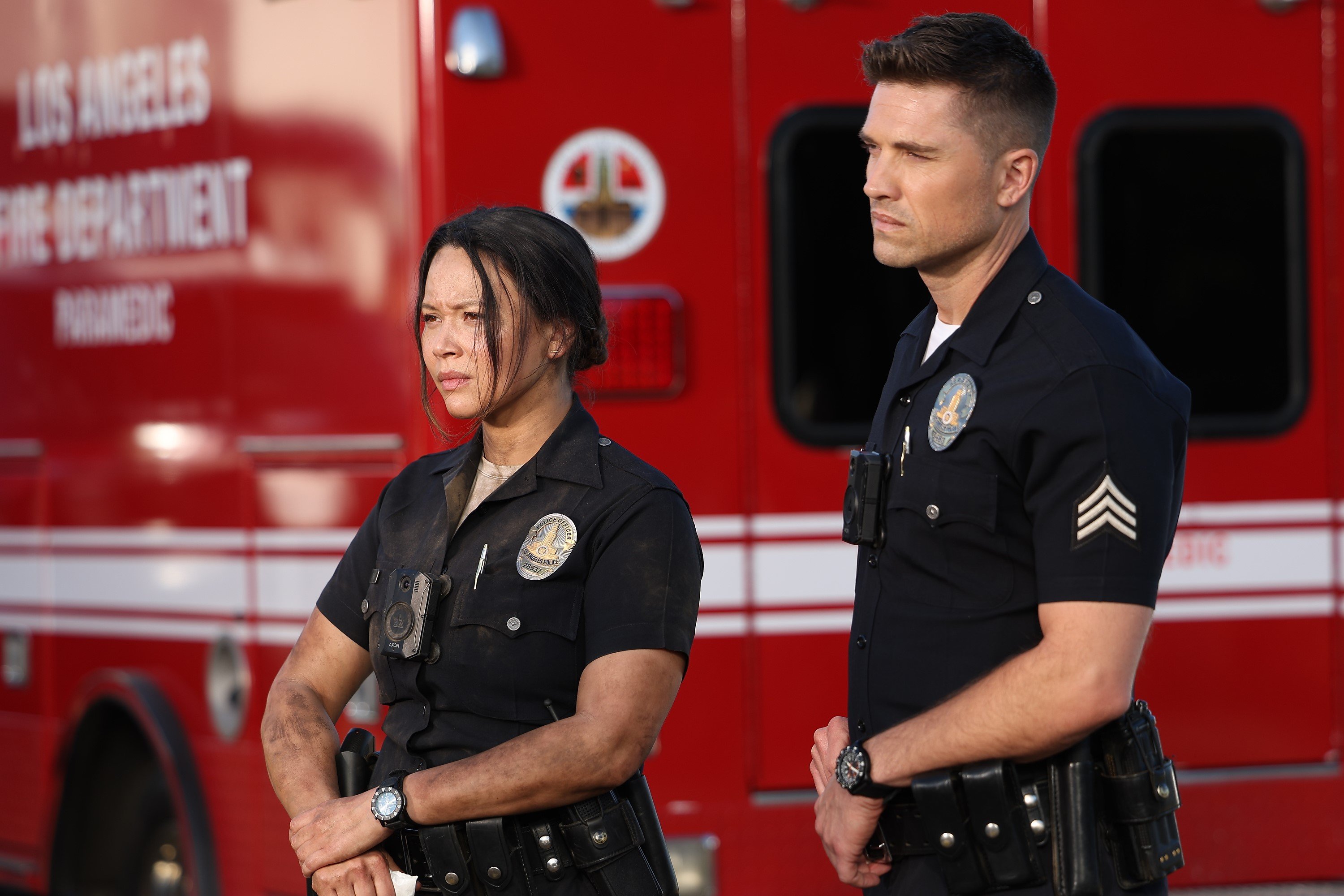 Melissa O'Neil and Eric Winter, in character as Lucy and Tim in 'The Rookie' on ABC, share a scene wearing their dark blue police uniforms.
