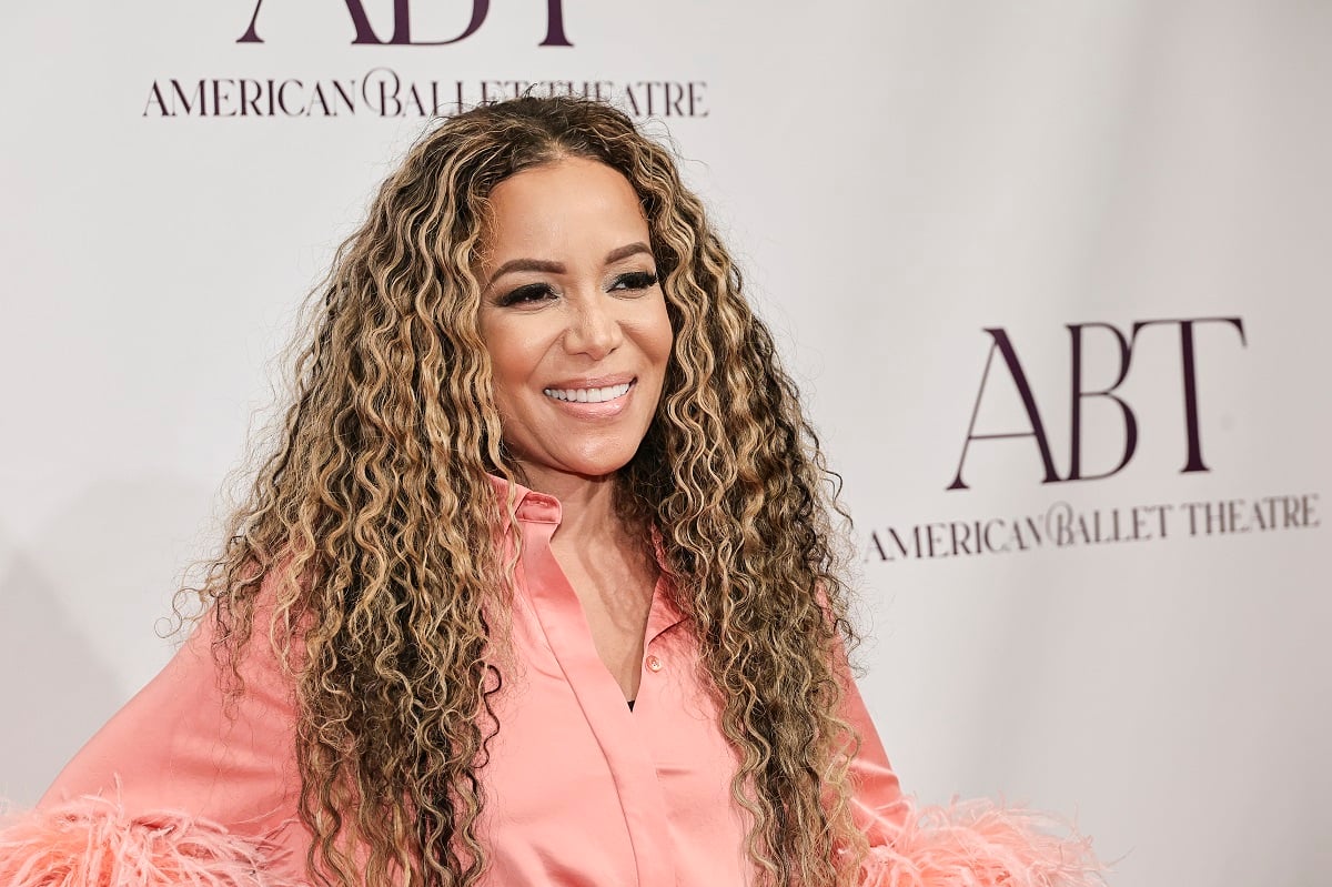 'The View' host Sunny Hostin wearing a pink dress and smiling for a red carpet photo.