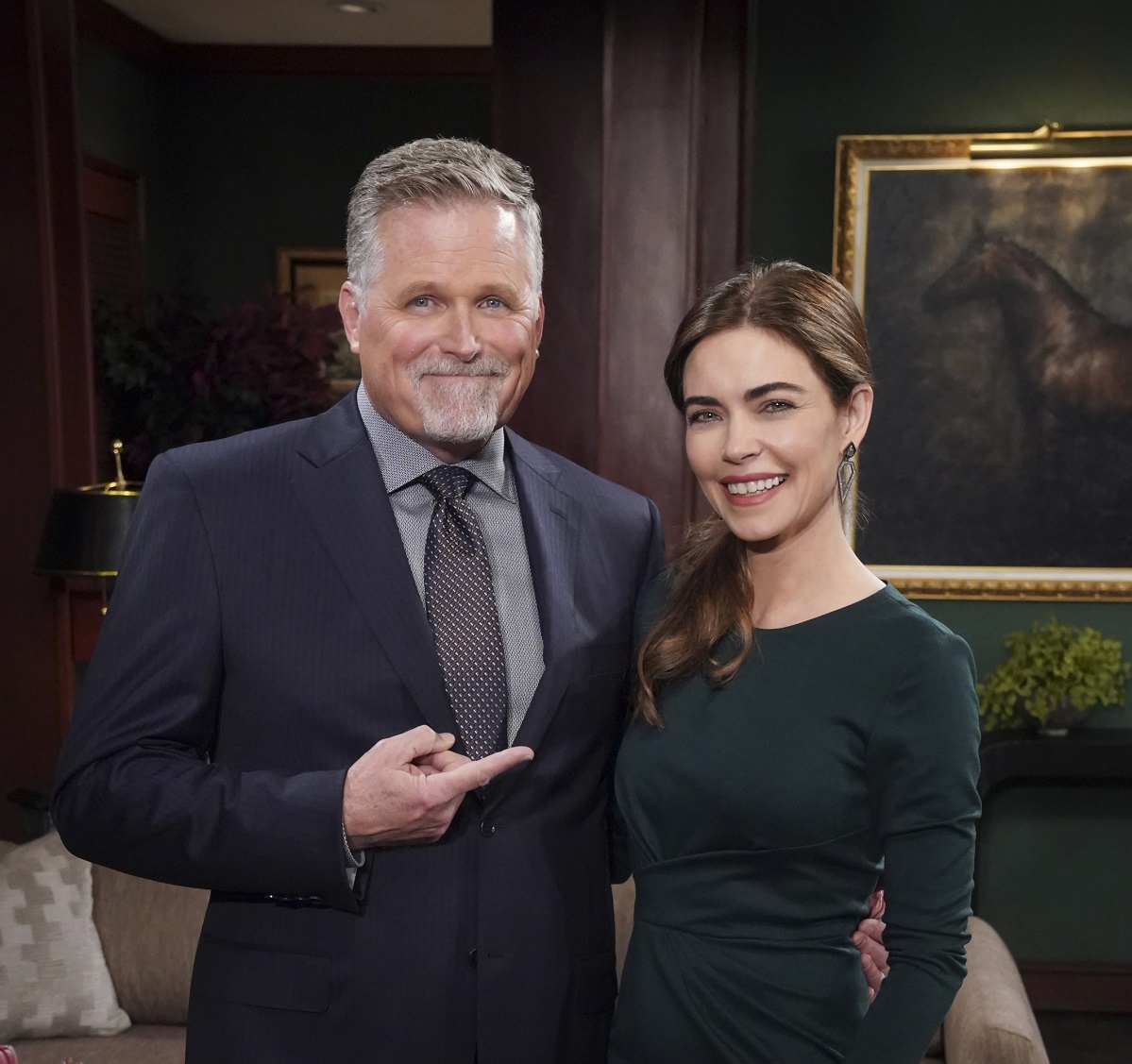 'The Young and the Restless' star Robert Newman in a blue suit, and Amelia Heinle in a green dress; posing together on set.