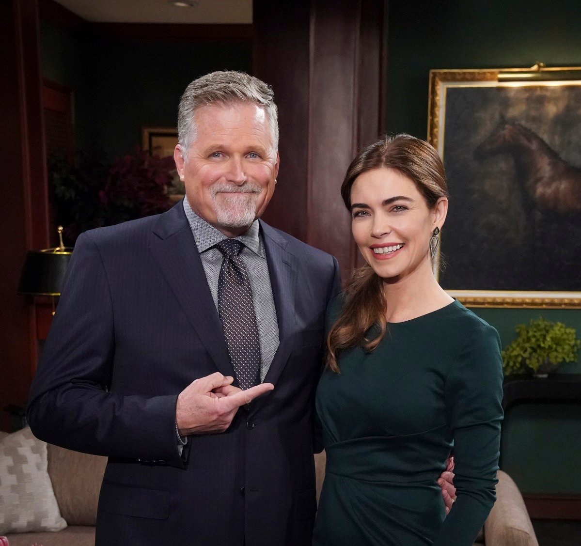 'The Young and the Restless' star Robert Newman in a blue suit, and Amelia Heinle in a green dress; posing together on set.