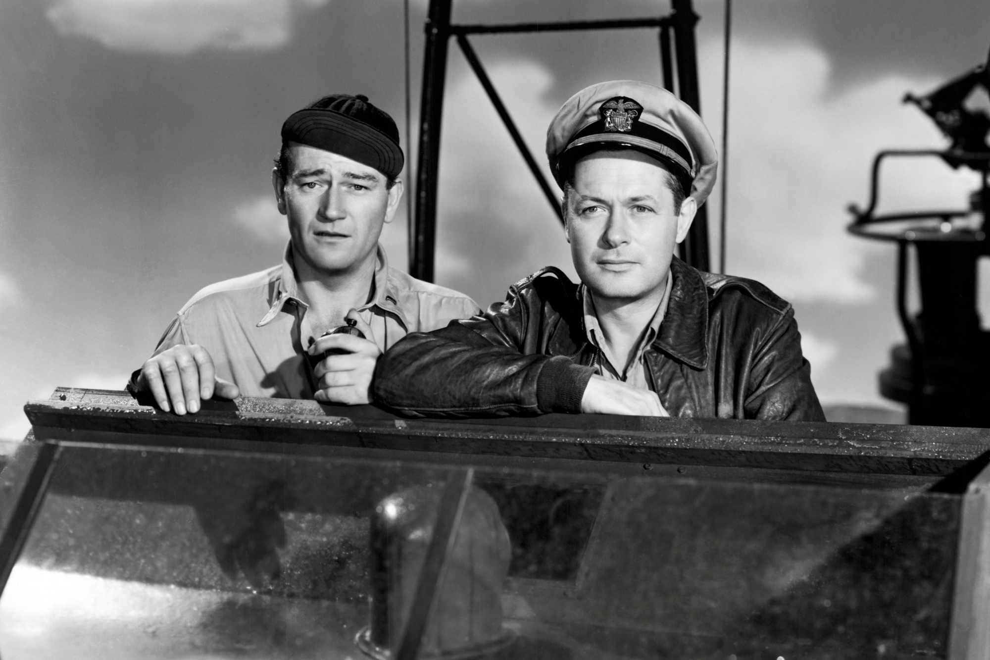 'They Were Expendable' movie stars Robert Montgomery as Lt. John Brickley and John Wayne as Lt. Rusty Ryan in a black-and-white picture wearing Navy uniforms looking serious