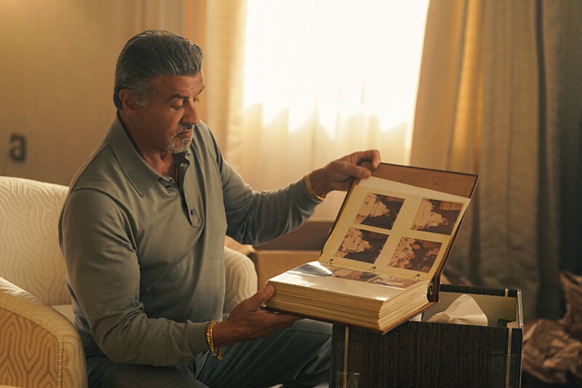 In Tulsa King, Dwight looks through a photo album while sitting in his hotel room.