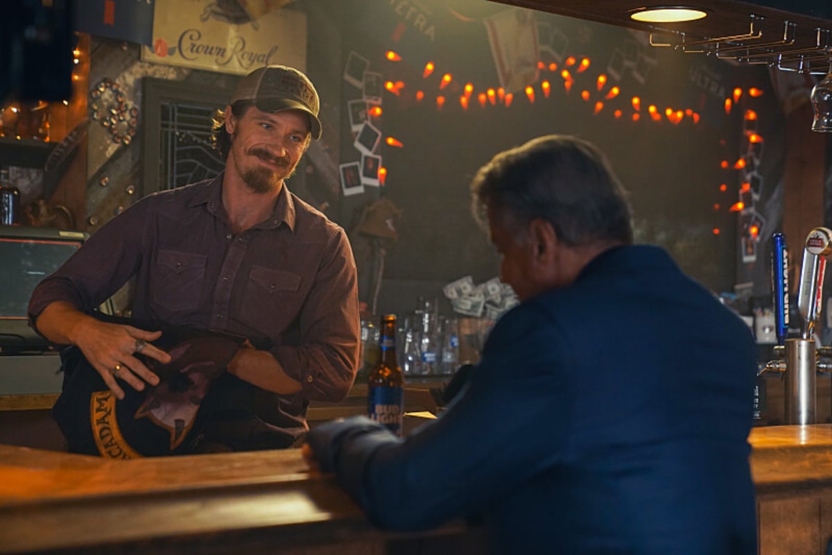 In Tulsa King Episode 7, Mitch hold Carson Pike's kutte and talks to Dwight, who is seated at the bar.