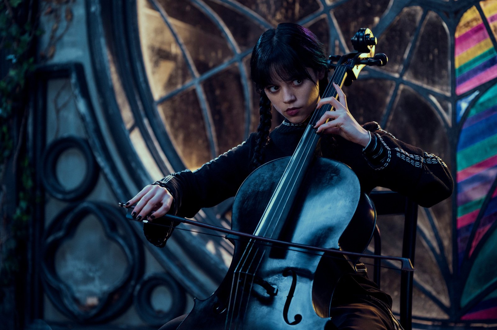 Jenna Ortega as Wednesday Addams in 'Wednesday' for our article about the Netflix show's weekly viewership. She's playing an instrument.